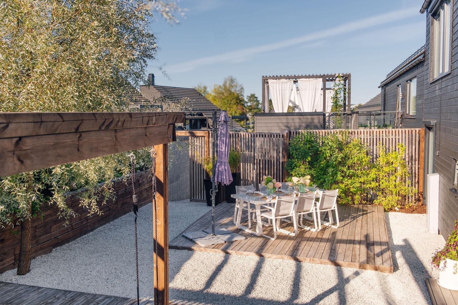 Uteområde på forsiden av huset har sol fra midt på dagen til sent på kvelden hele sommeren. Området er rammet inn med et høyt spilegjerde og frodig beplantning som gjør dette til en skjermet privat oase. Galleribilde
