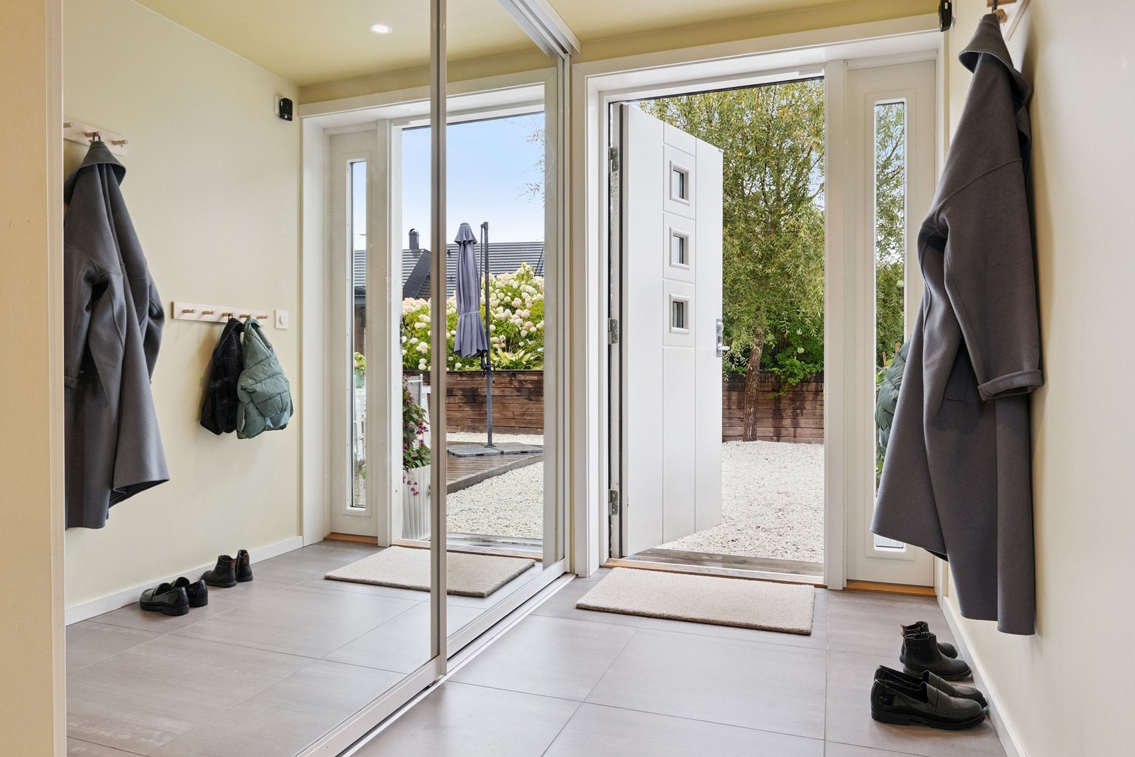 Lys gang med stor skyvedørsgarderobe med speil. Galleribilde