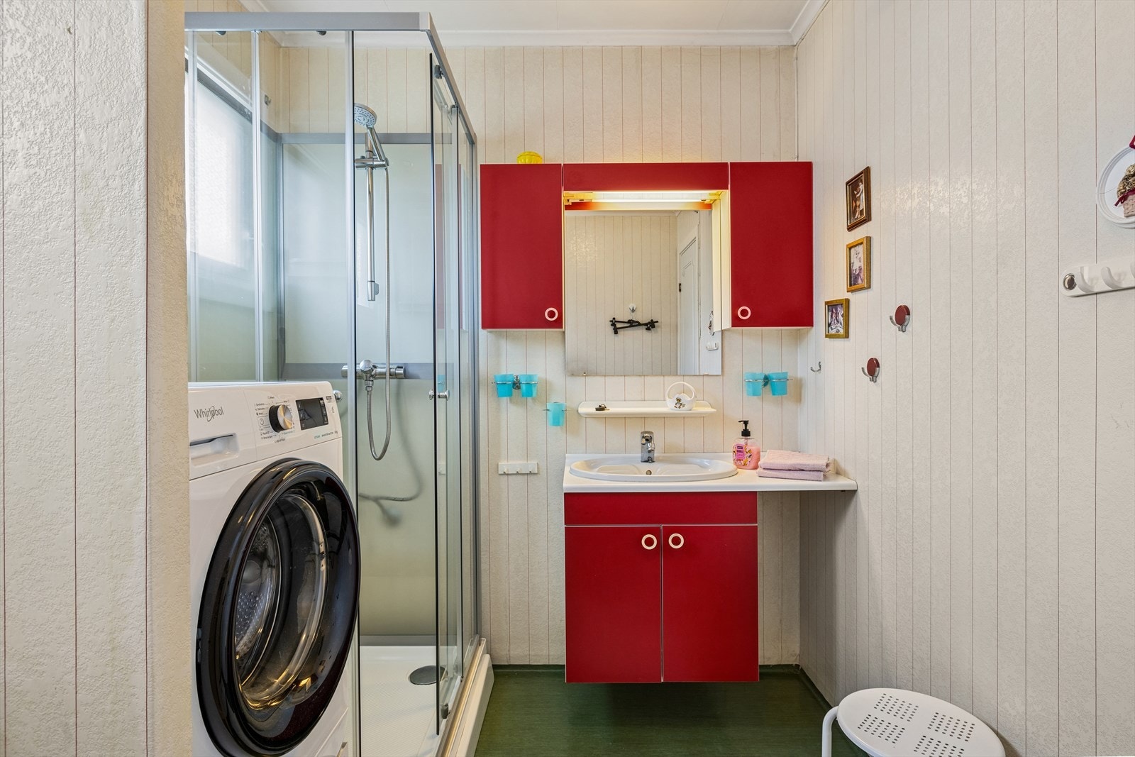 Badet i 1. etasje har belegg på gulv og plater på veggene. Det er innredet med dusjkabinett, servant og toalett. Galleribilde
