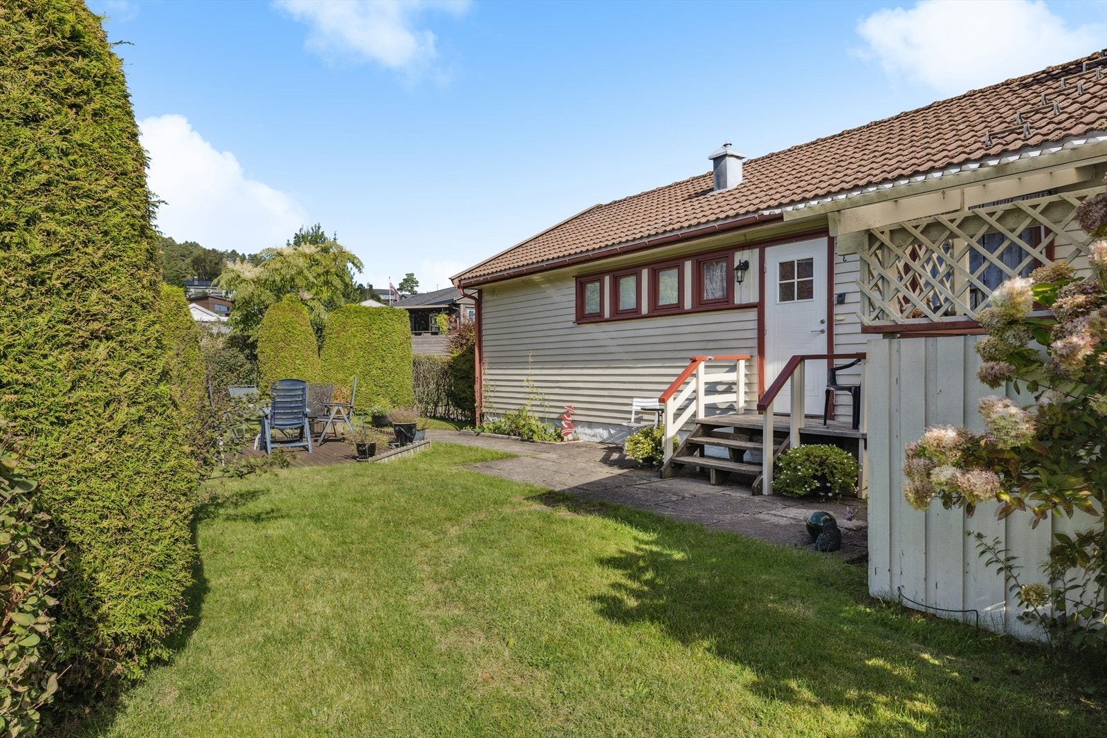 Boligen har adkomst via gruslagt gårdsplass med heller fram til trapp opp til inngangspartiet. Galleribilde