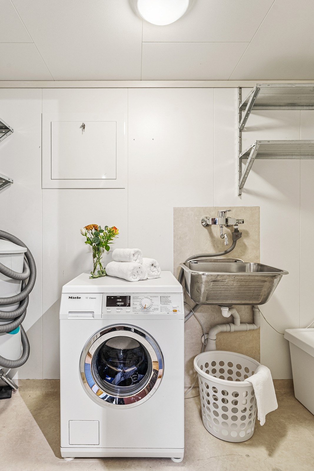 Vaskerom/Bod er innredet med en enkel vask i stål, opplegg for oppvaskmaskin og en frittstående varmtvannsbereder. Galleribilde