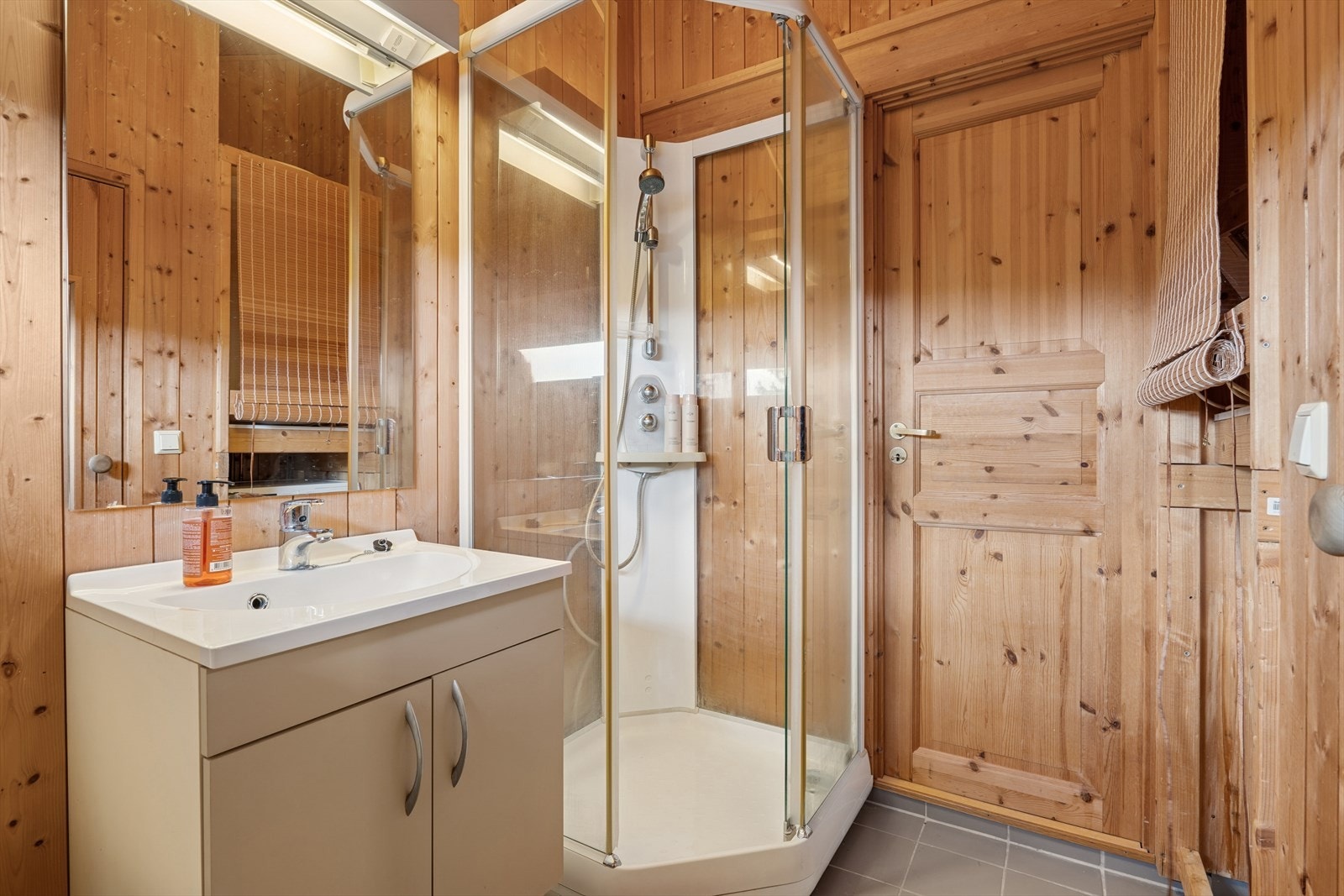 Baderom med servant nedfelt i underskap, dusjkabinett og toalett Galleribilde