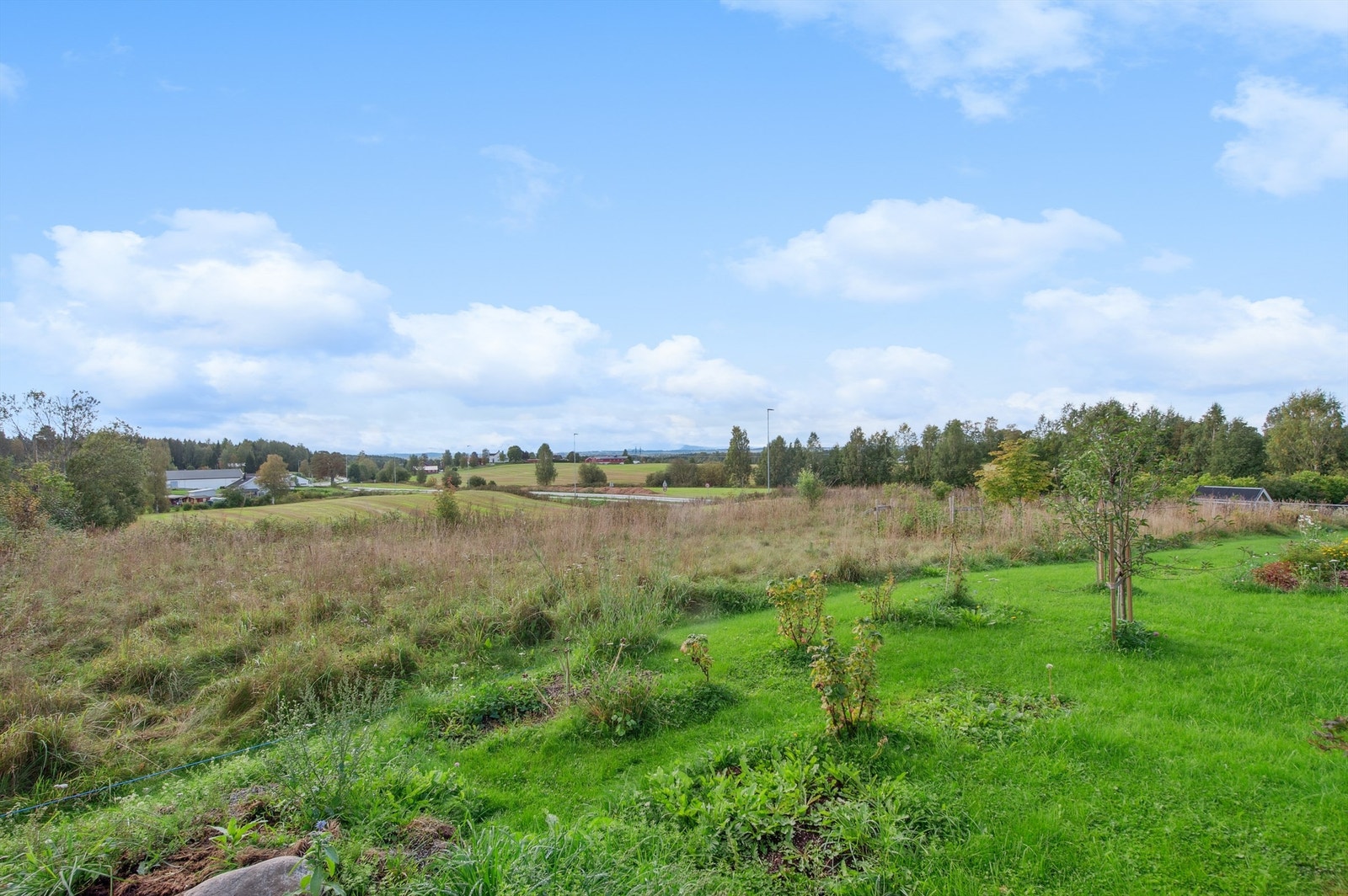 Eiendommen ligger høyt i terrenget, noe som gir en åpen og landlig ramme rundt tomten. Galleribilde
