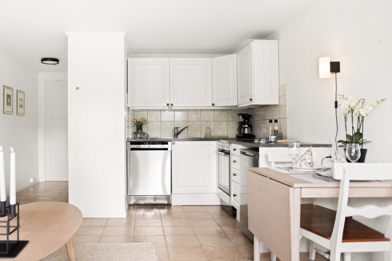 Kjøkkenet har en praktisk innredning med profilerte fronter i lyse toner og en laminert benkeplate som gir god arbeidsflate. Galleribilde