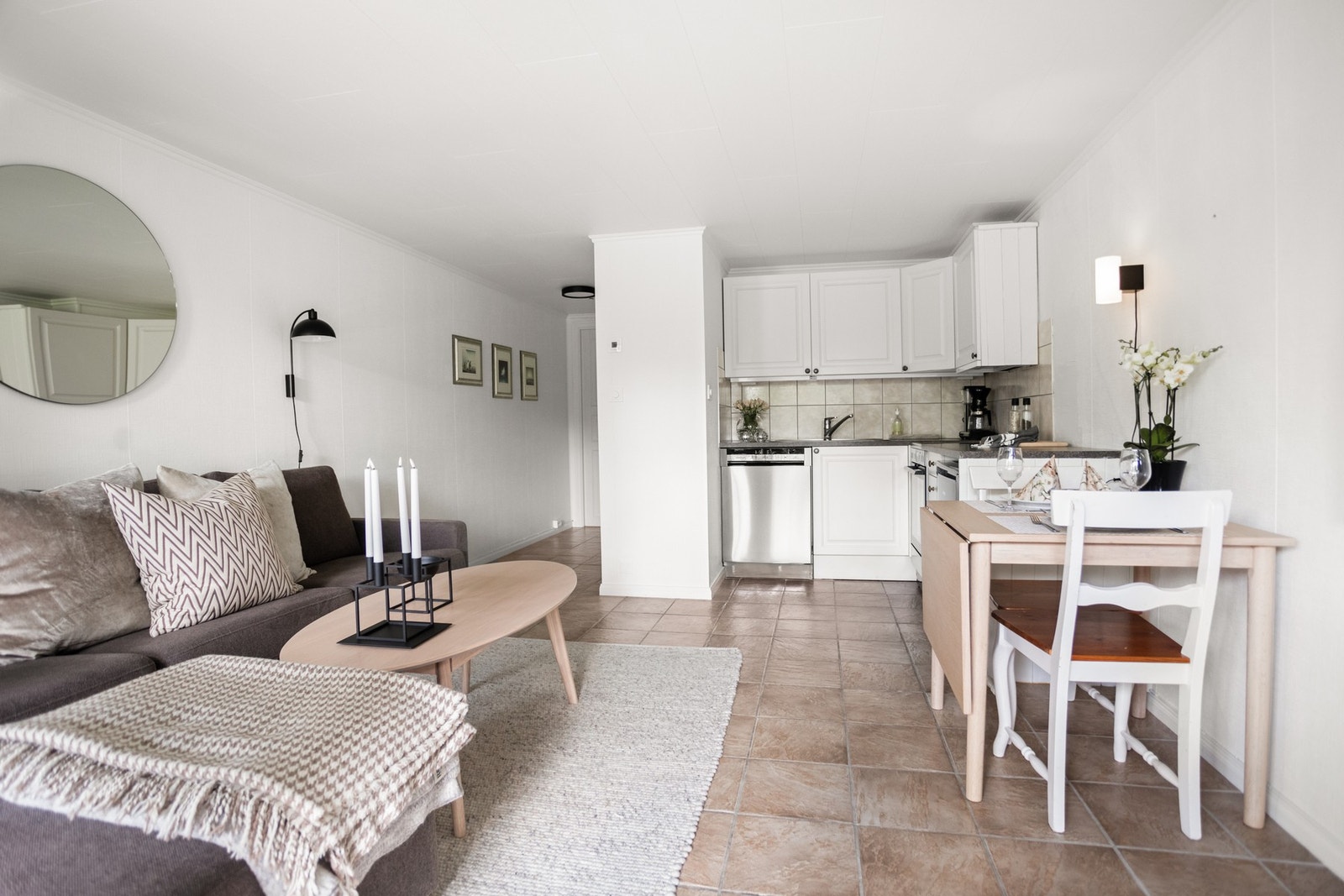 Det er åpen løsning mellom stue og kjøkken, og rommet har flislagte gulv. Det er kjøkkeninnredning med lyse, profilerte fronter, og laminert benkeplate. Galleribilde