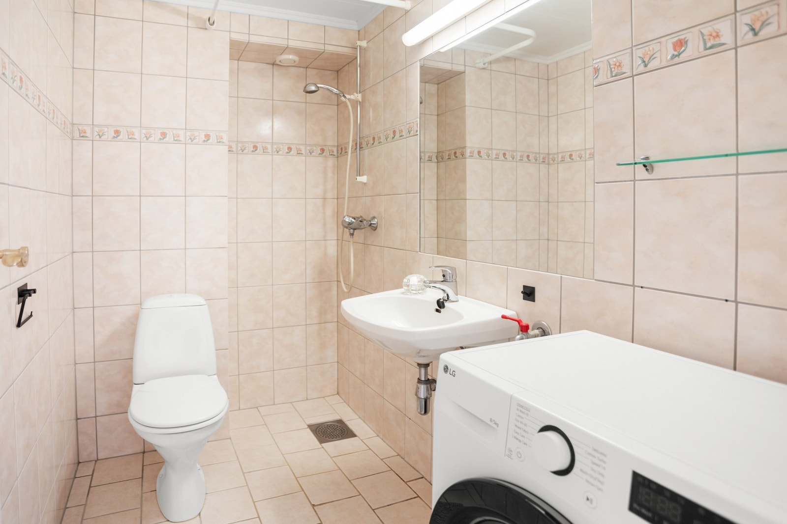 Badet er flislagt med varmekabler, og inneholder dusjhjørne, wc og servant med speil. Galleribilde