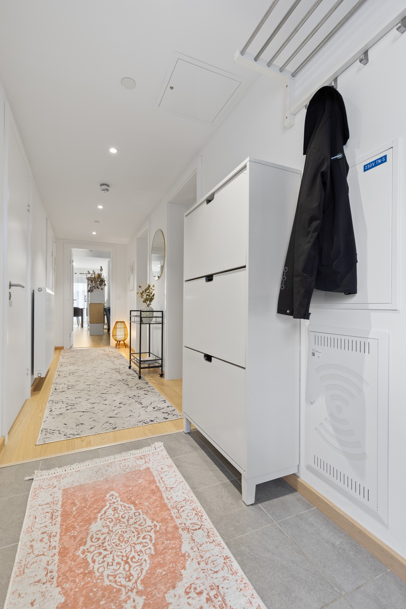 Tiltalende entre med delikate storformatfliser på gulv som gir et godt førsteinntrykk av leiligheten. Rommet er holdt i lyse moderne fargevalg, noe som er gjennomgående for de øvrige oppholdsrommene. Galleribilde