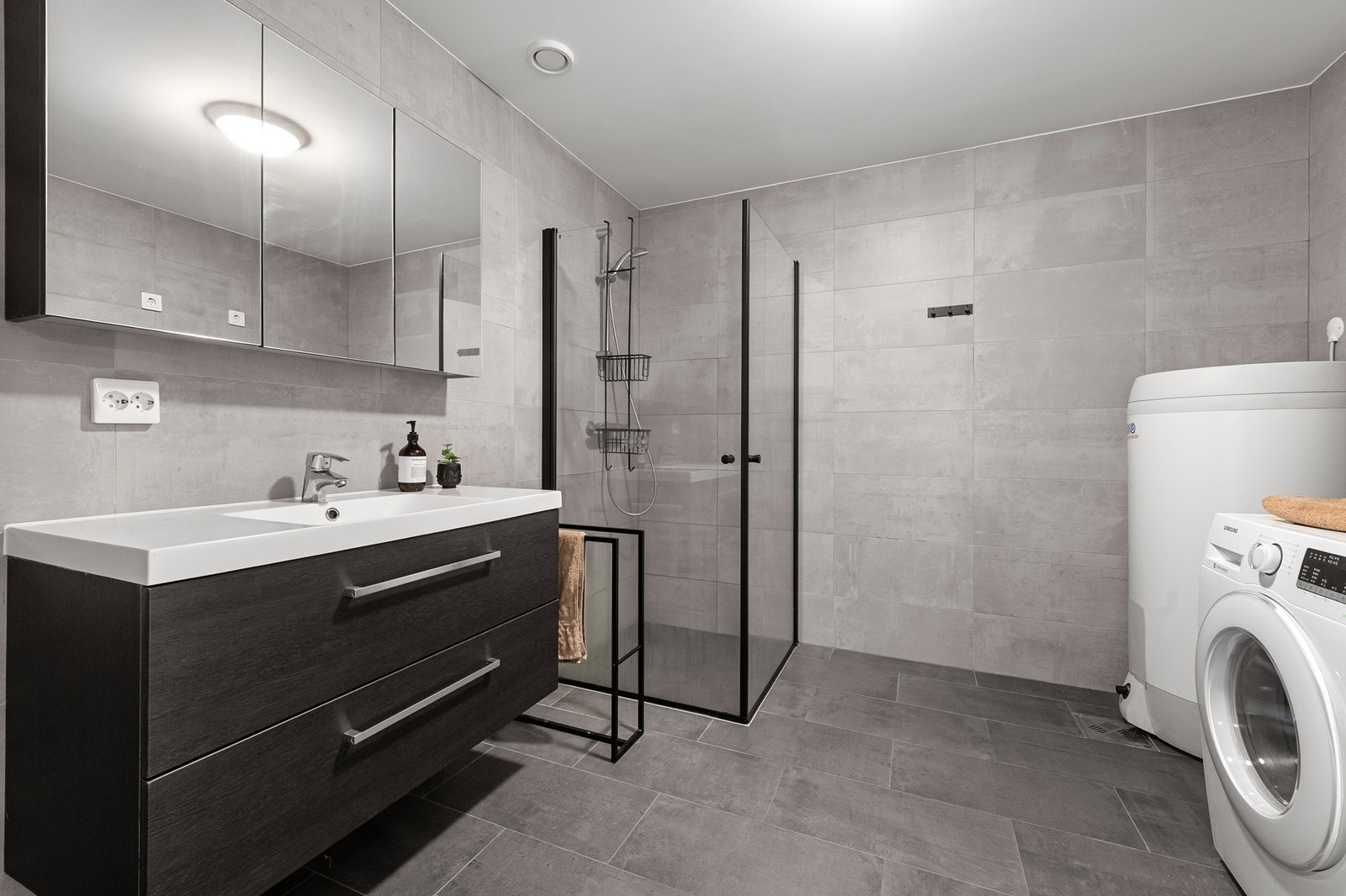 Badet er innredet med baderomsinnredning, dusjhjørne, toalett og opplegg for vaskemaskin. Galleribilde