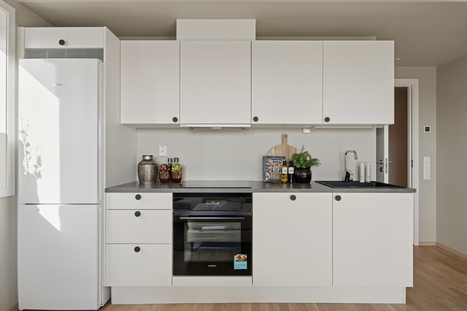 Integrerte hvitevarer som kjøl/frys, oppvaskmaskin, platetopp og komfyr. Galleribilde