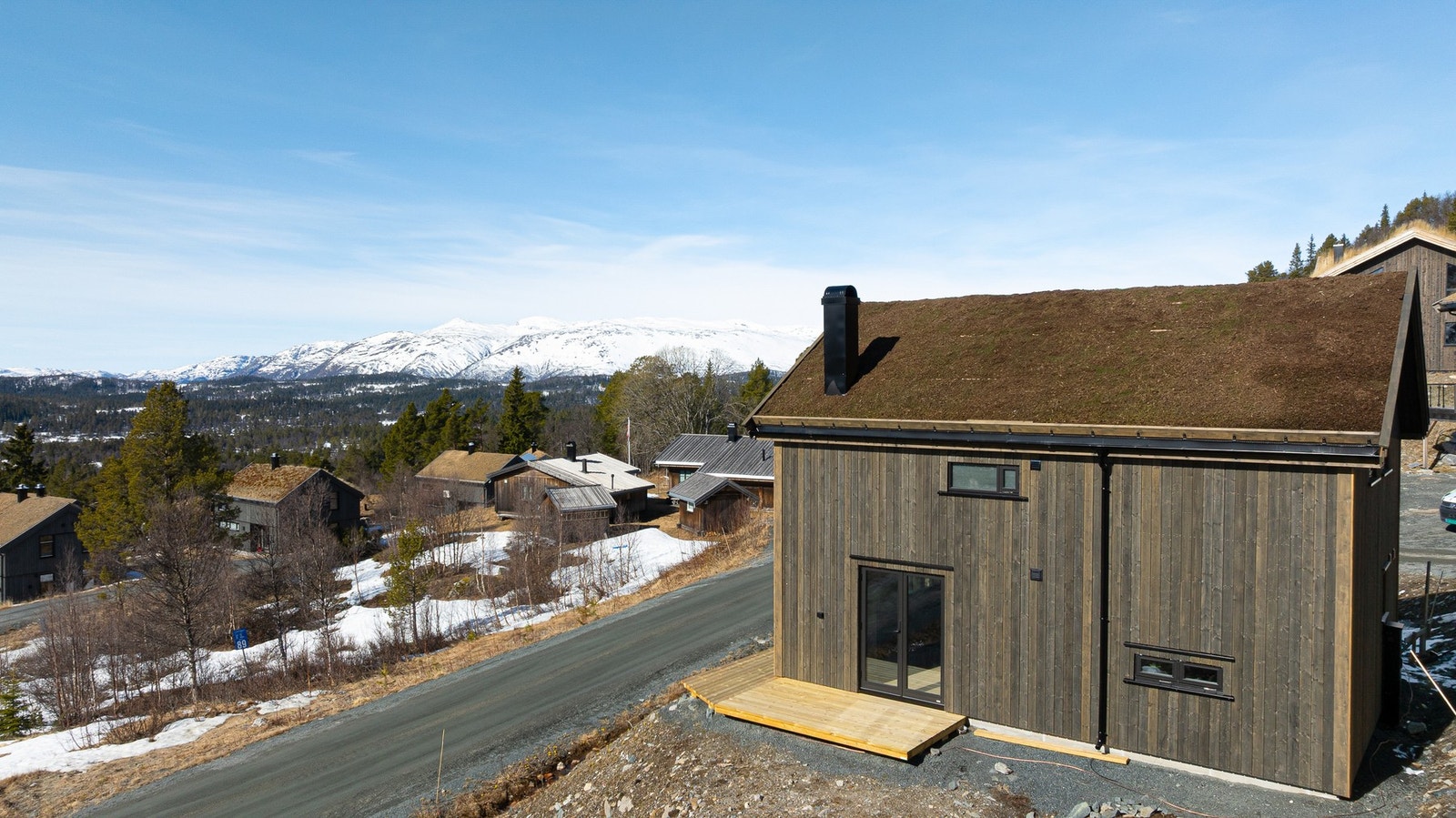 Terrasse som strekker seg rundt hytta, slik at man enkelt kan flytte seg etter solen. Om sommeren går sola ned rundt kl 22:00 Galleribilde