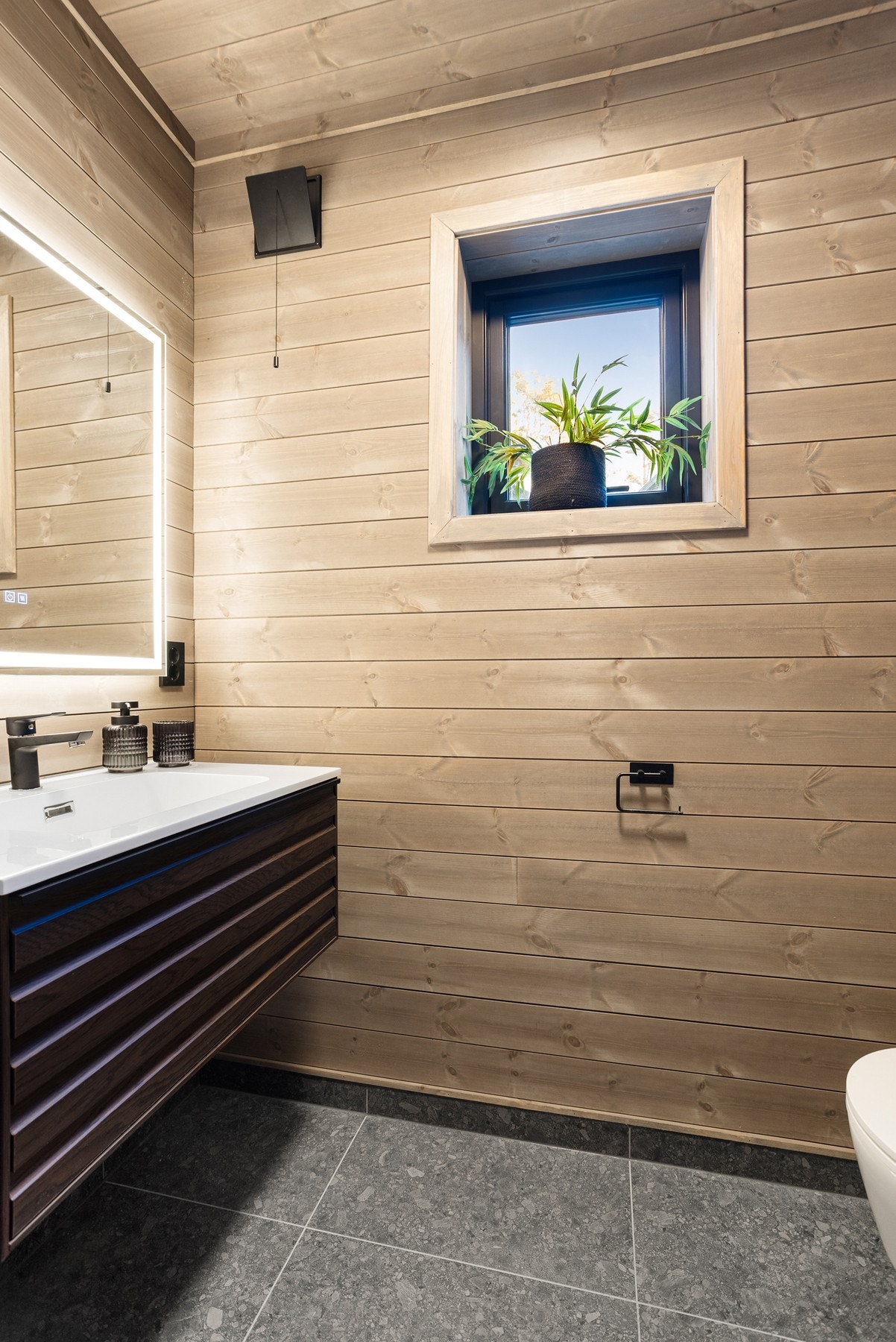 Praktisk toalettrom, med veggmontert toalettrom og innredning med servant. Galleribilde