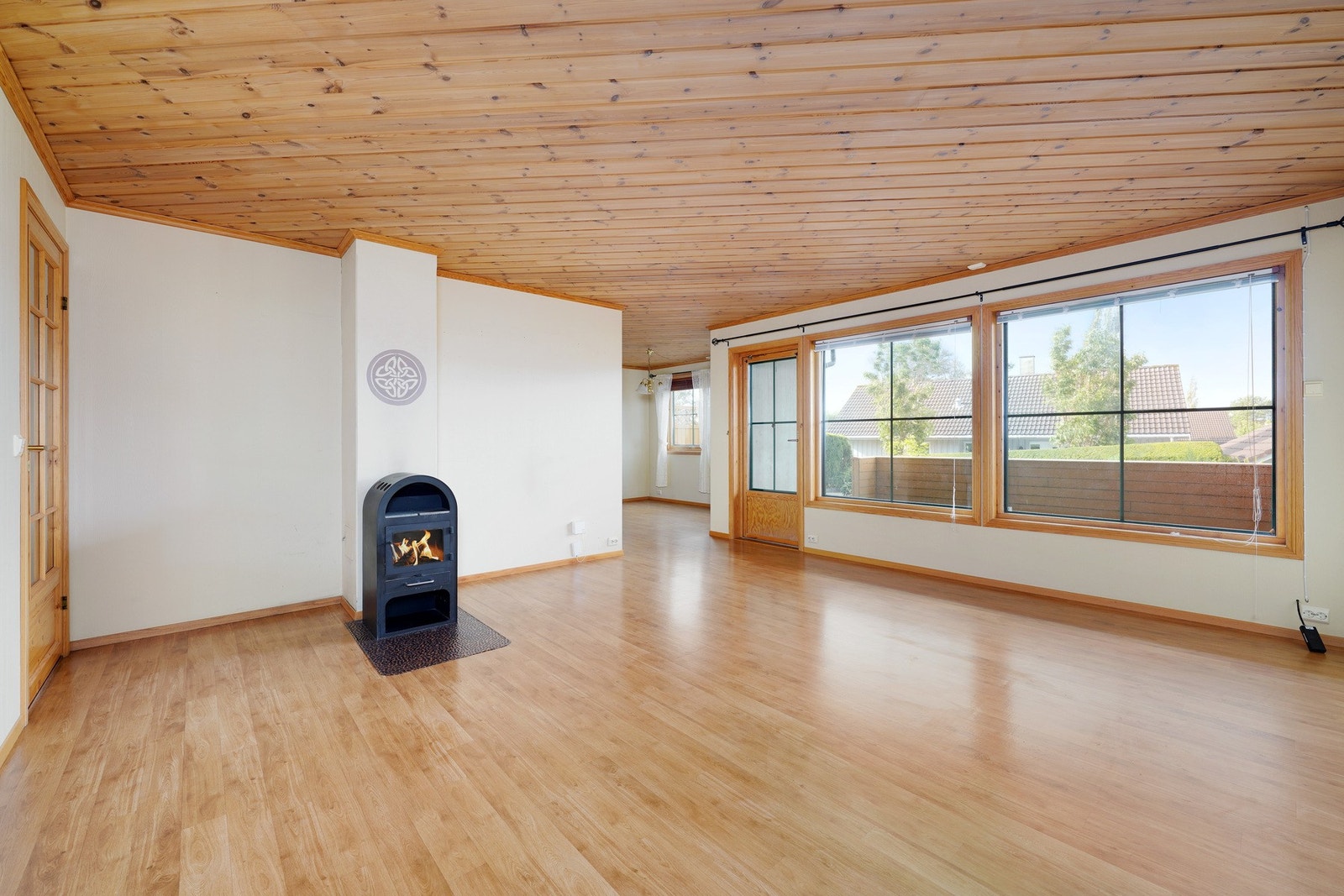 Romslig stue med peis og store vindusflater som fanger opp mye naturlig lys. Galleribilde