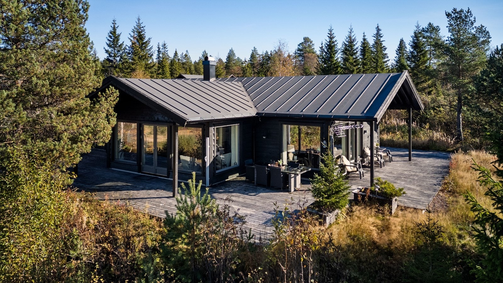 Stor, solrik markterrasse rundt store deler av hytta Galleribilde