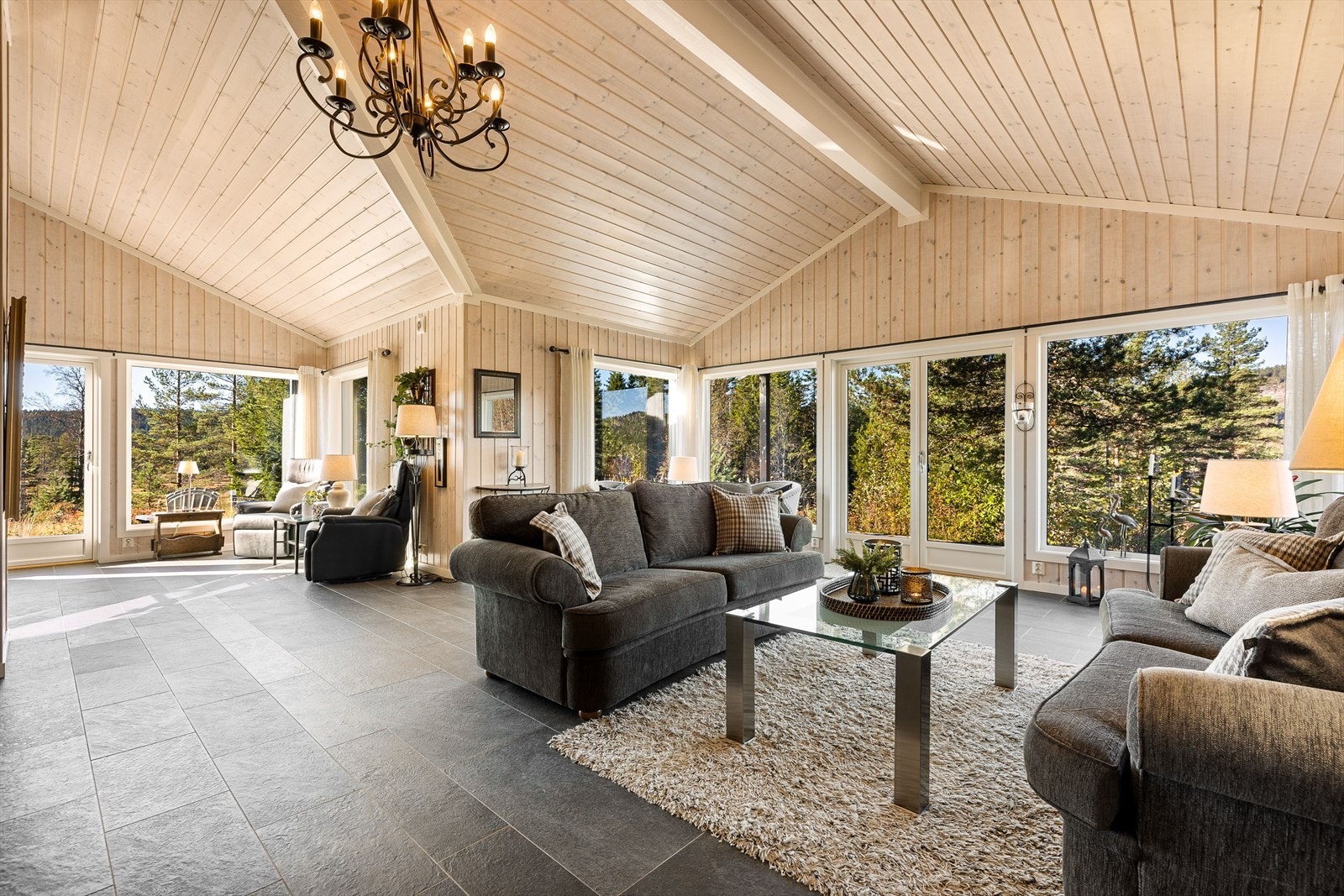 Stor stue med imponerende takhøyde og vinduer som slipper inn lys og utsikt Galleribilde