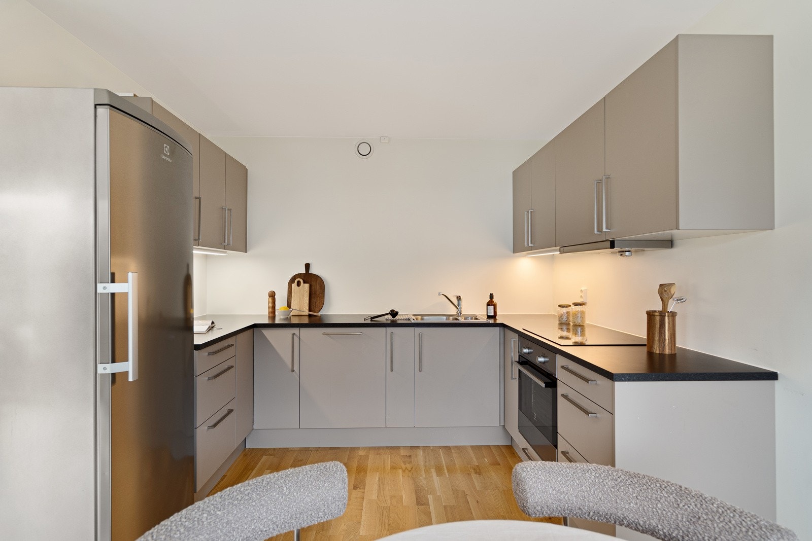 Pent kjøkken med grå, slett innredning - hvitevarer medfølger Galleribilde