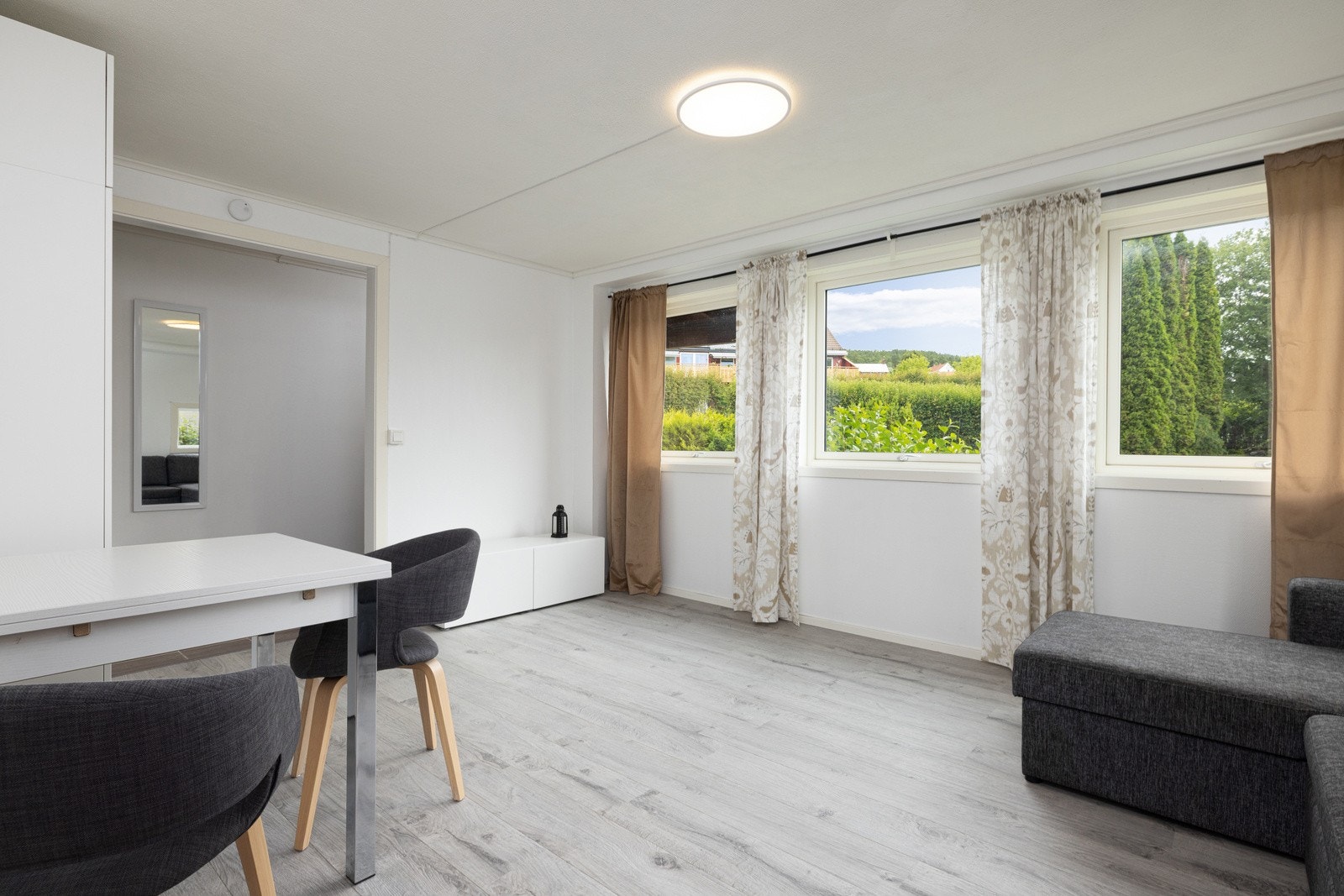 Store vindusflater ttilføyer en romslig og lys atmosfære til rommet. Galleribilde