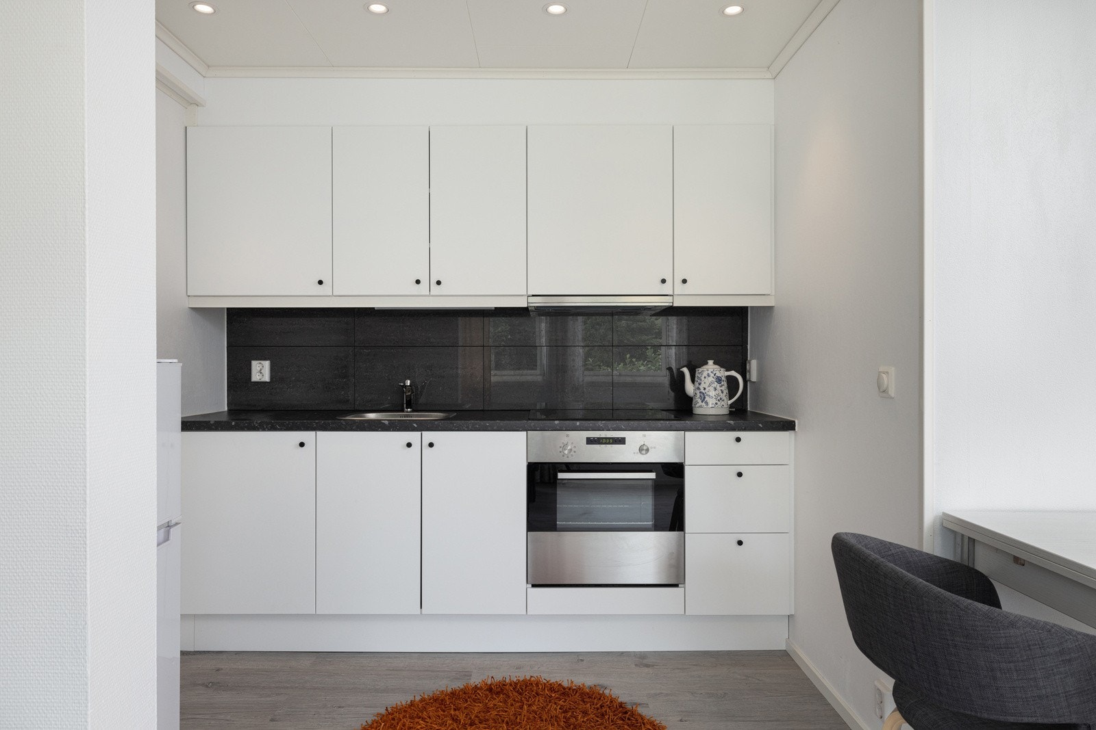 Kjøkkenet ligger i en åpen løsning mot stuen og byr på innredning med lyse, glatte fronter og en laminat benkeplate. Galleribilde