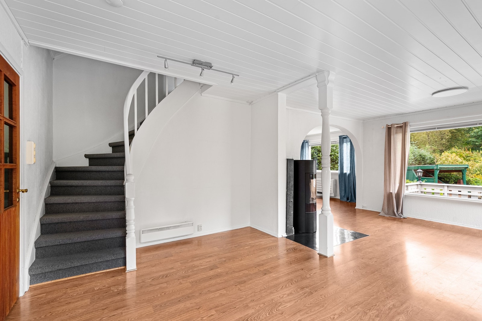 Rommelig stue med store vindusflater mot den vakre hagen Galleribilde