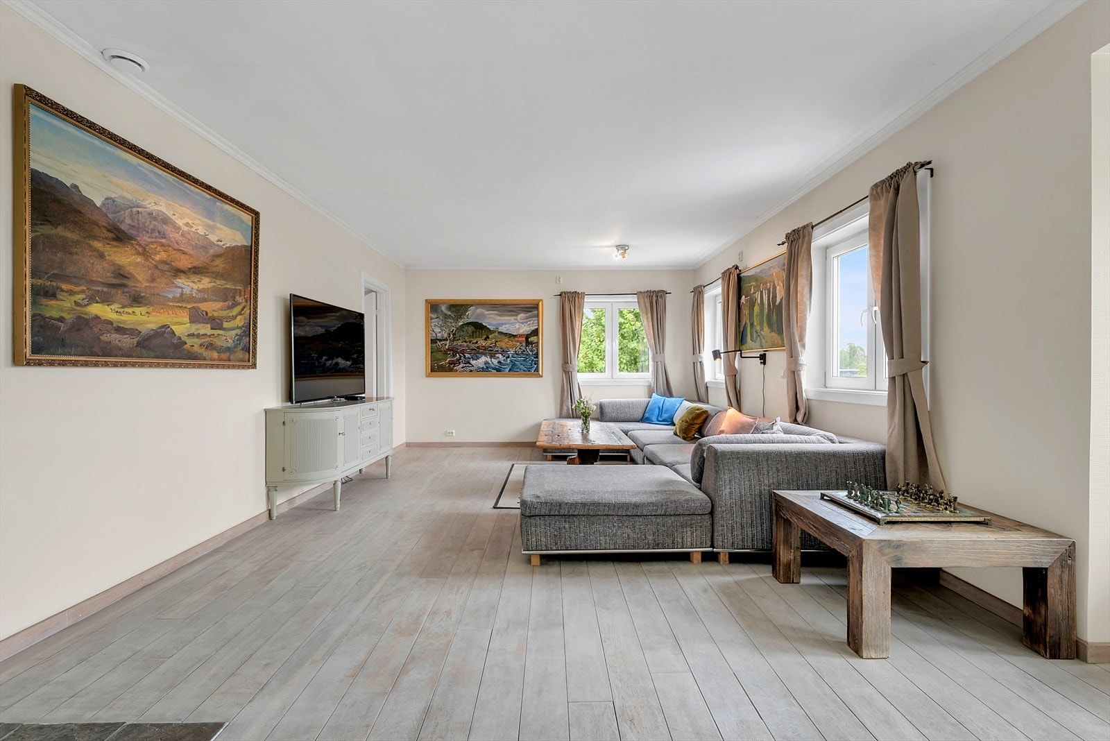 Det er god plass til sofaseksjon, tv-møblement og spisebord. Galleribilde