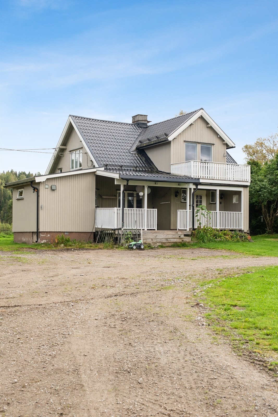 Fasaden er kledd med stående perlestaffpanel, og ved inngangspartiet finner man en takoverbygget veranda. Galleribilde