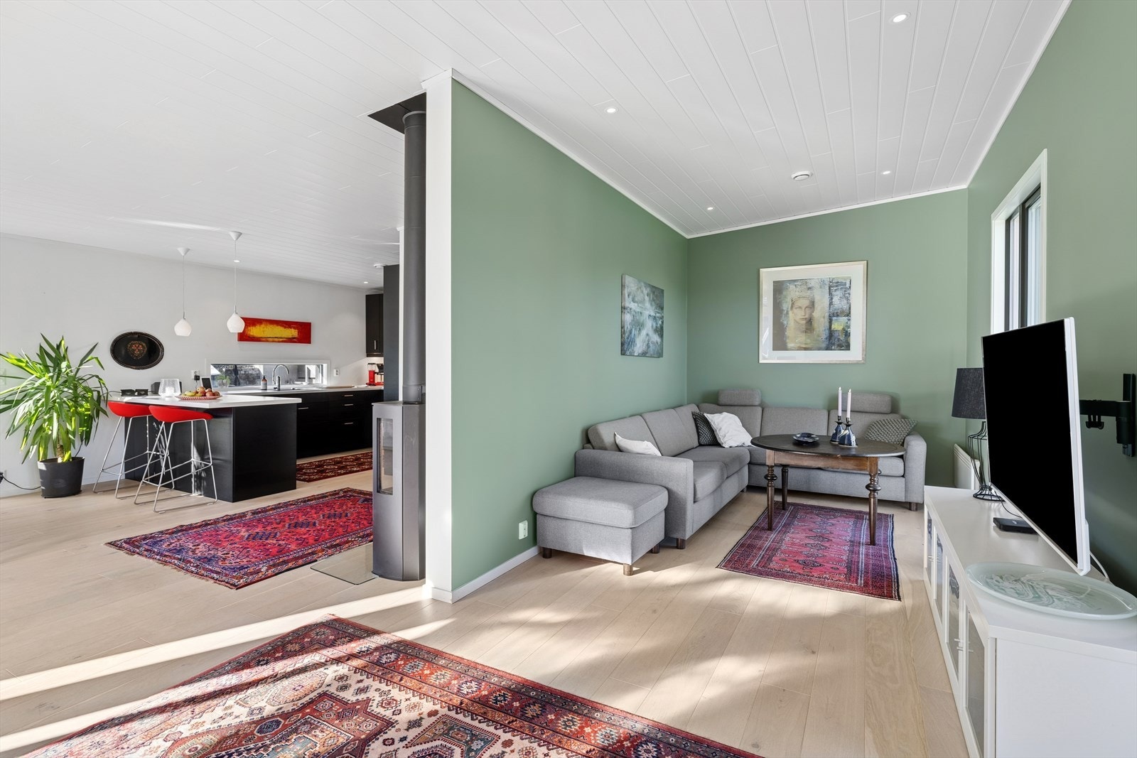 Stuen har utstrakt bruk av downlights, parkett på gulv og er malt i moderne farger som passer godt inn. Galleribilde