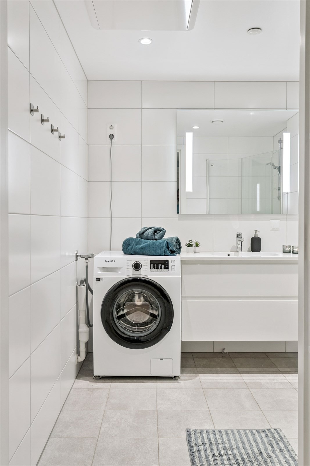 Baderomsinnredningen har heldekkende servant og speil med integrert lys. Elektriske varmekabler i gulvet. Galleribilde