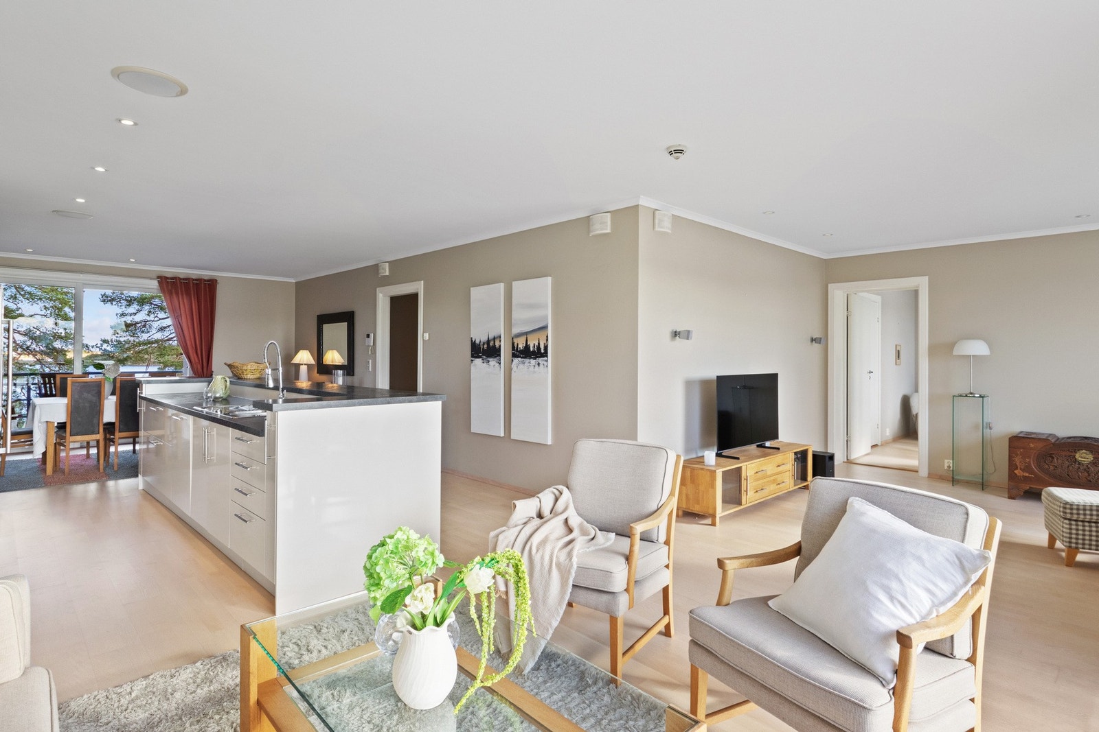 Åpen løsning mellom stue og kjøkken skaper et sosialt og moderne allrom. Galleribilde