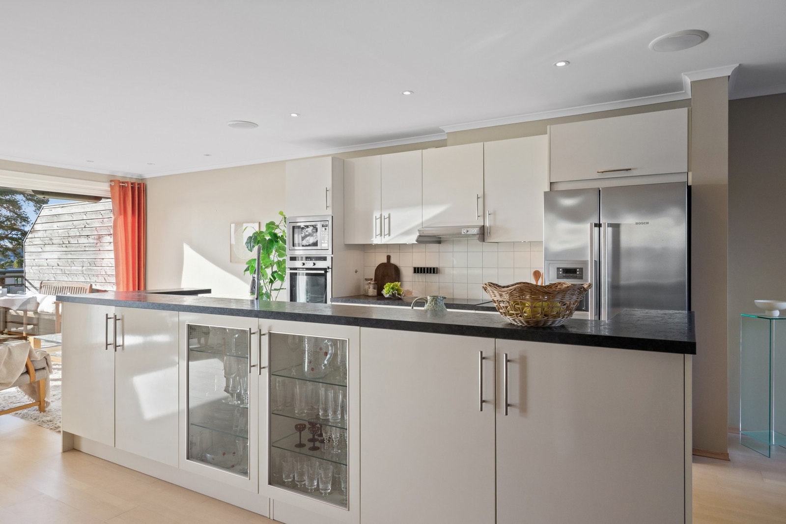 Stor kjøkkenøy fungerer som et naturlig samlingspunkt og gir både ekstra sitteplasser og arbeidsflate. Galleribilde