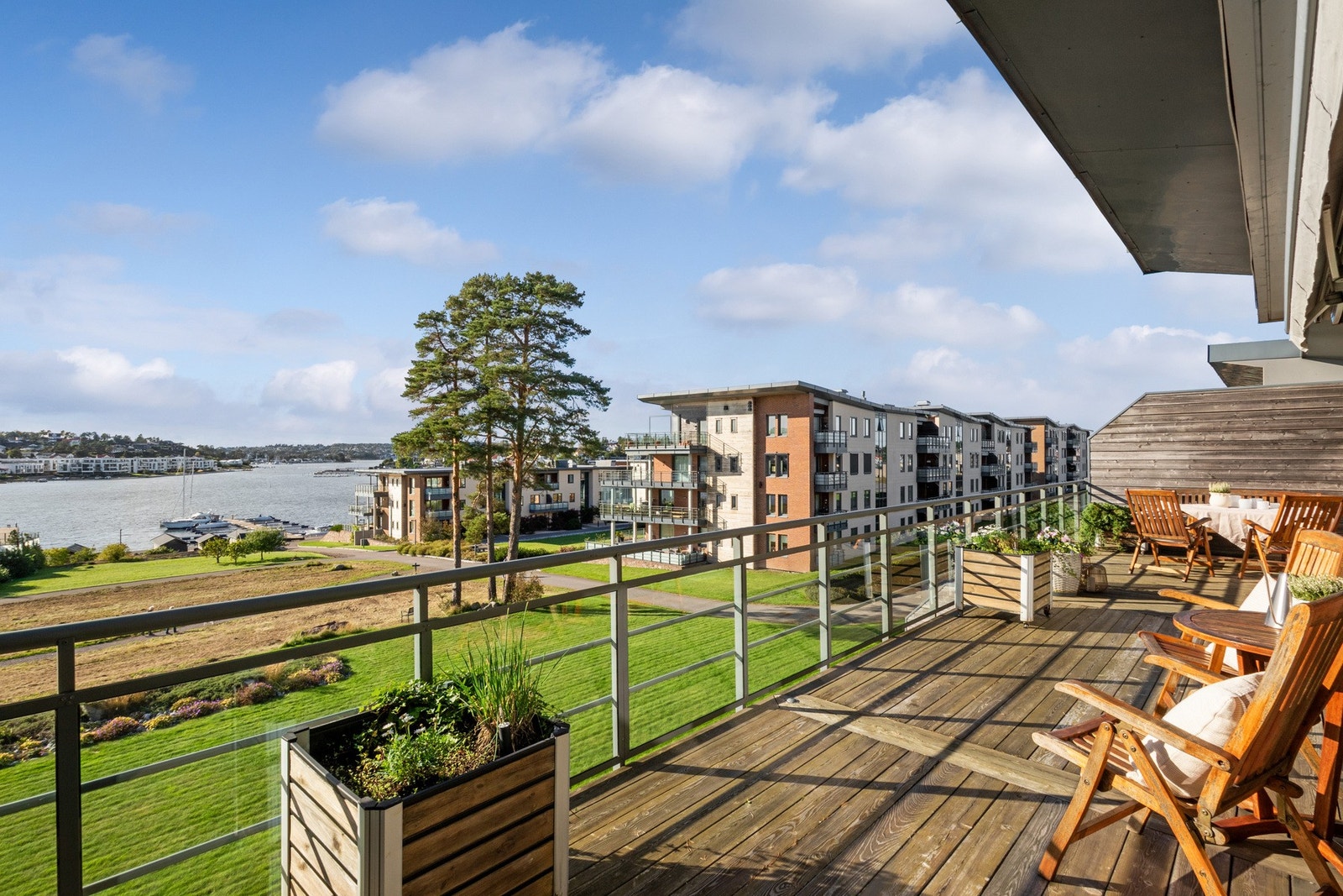 Glassrekkverk gir uhindret utsikt og en moderne ramme rundt uteplassen. Galleribilde