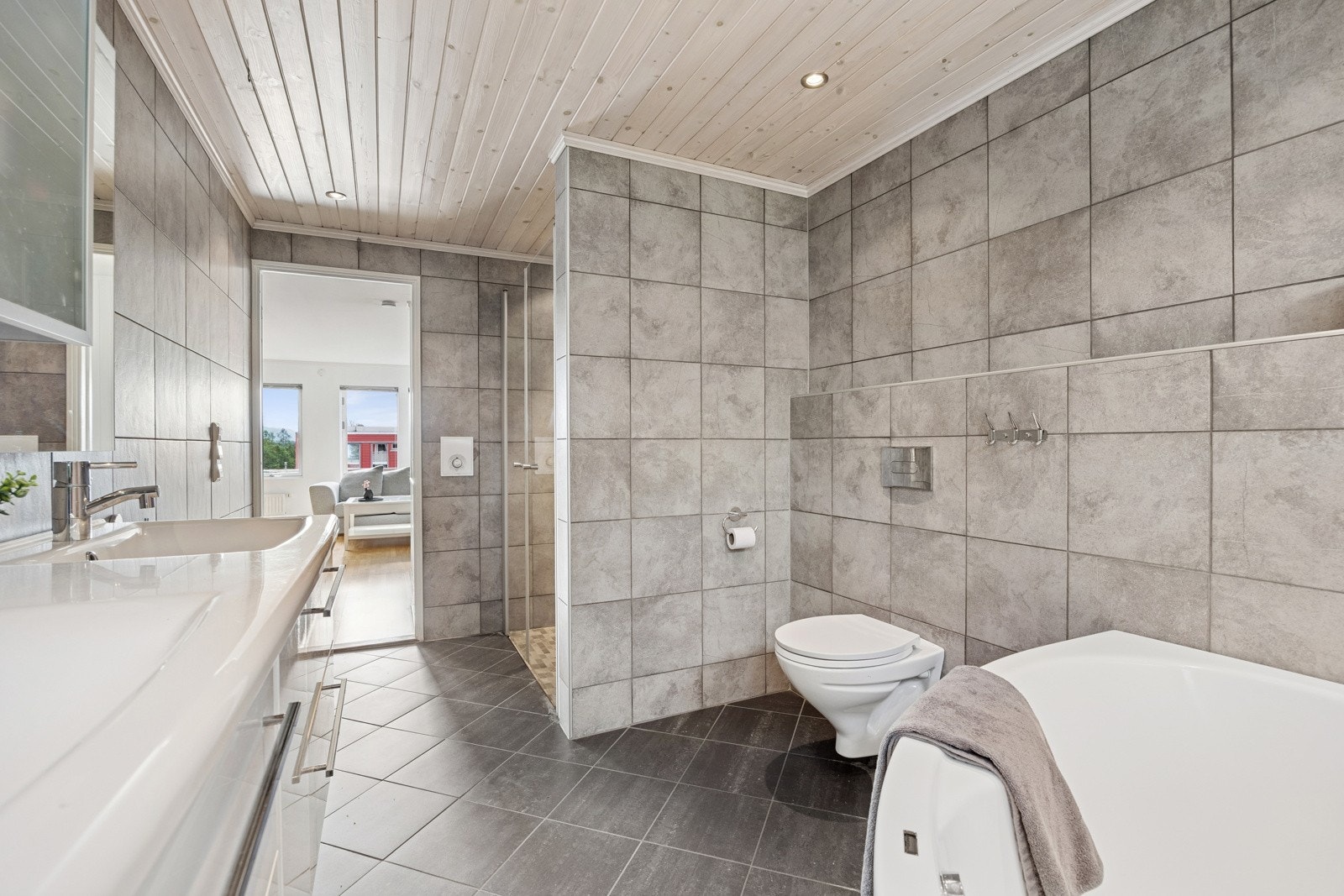 Det ca. 9 kvm store badet er stilrent innredet med delikate fliser på vegger og gulv. Galleribilde