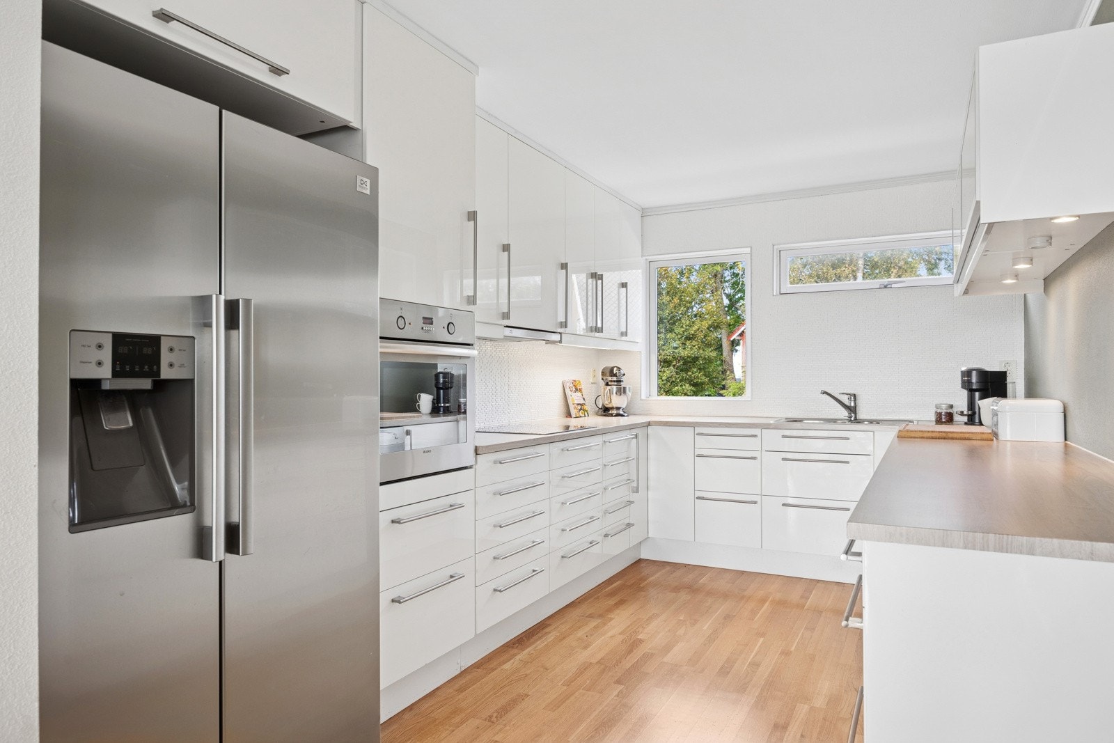 På kjøkkenet er det lett å skape matglede og tilberede gode måltider over en romslig arbeidsbenk som strekker seg over flere soner. Galleribilde