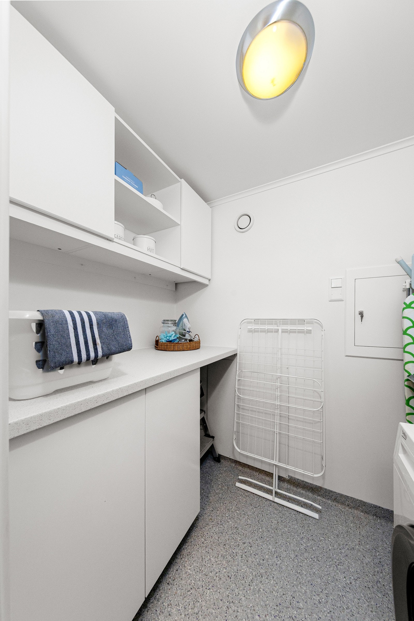 Vaskerommet har praktisk innredning med skap og laminert benkeplate samt vegghengte skap. Galleribilde