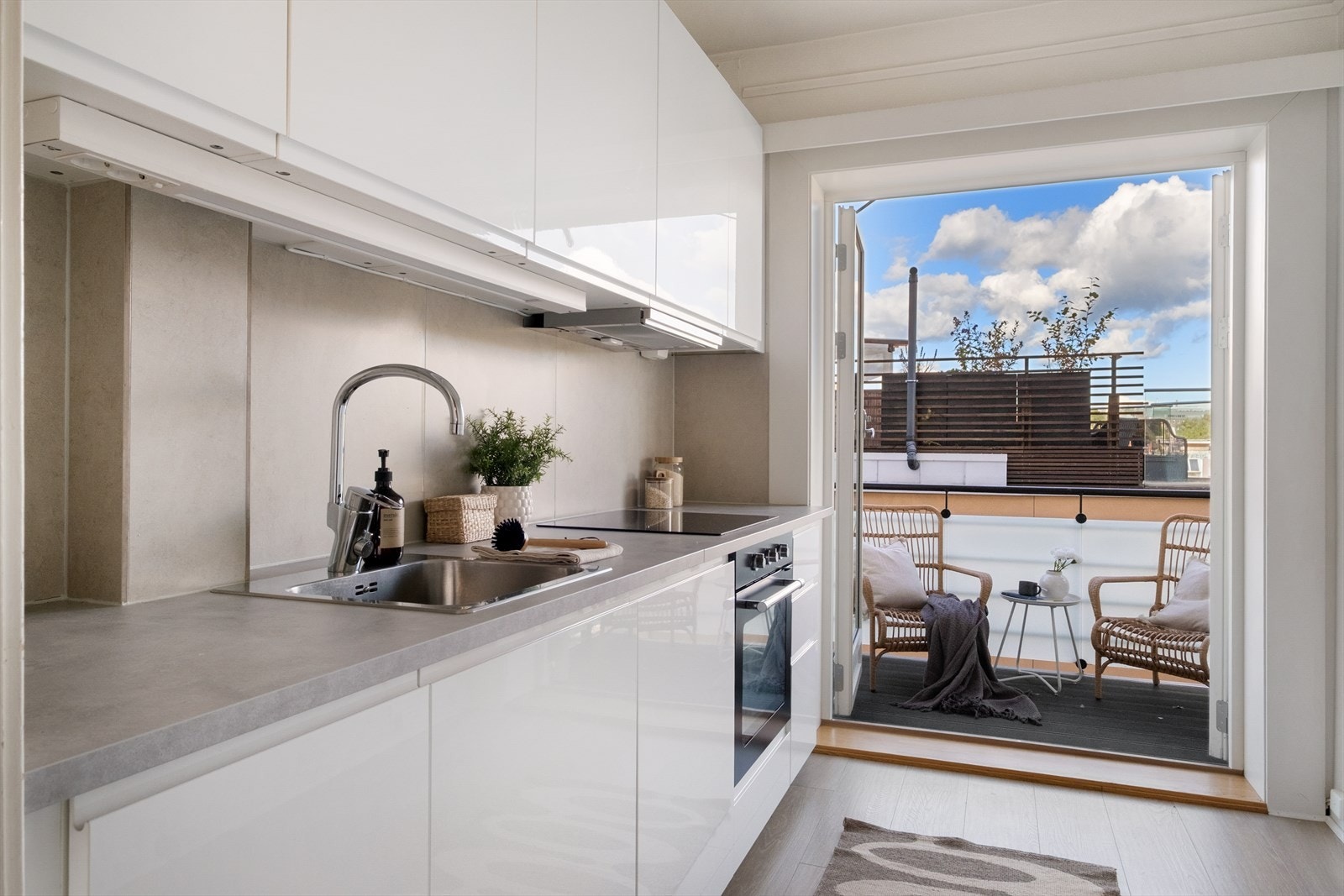 Tidsriktig glatt innredning fra IKEA, soft close, fliser over benk, armatur, laminat benkeplate med nedfelt stålkum og keramisk topp, integrert komfyr, oppvaskmaskin, kjøl/frys. Det er kjøkkenventilator med kullfilter. Galleribilde