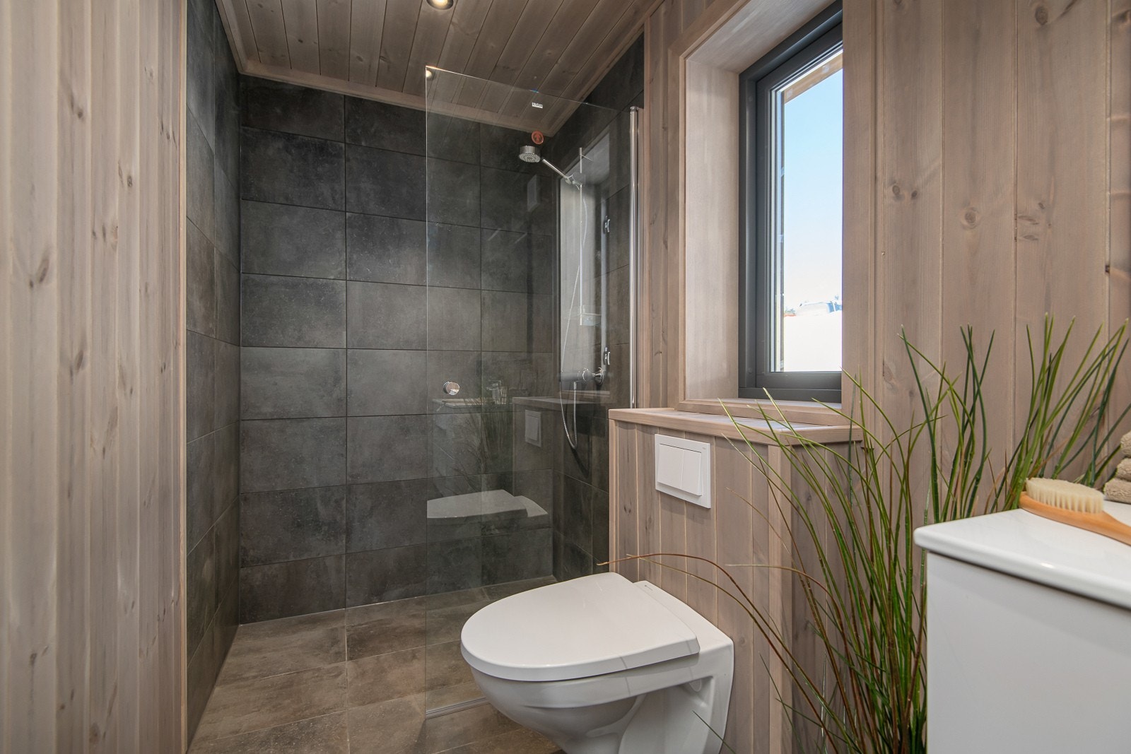 Baderom II er innredet med dusjsone, vegghengt wc og servantinnredning Galleribilde