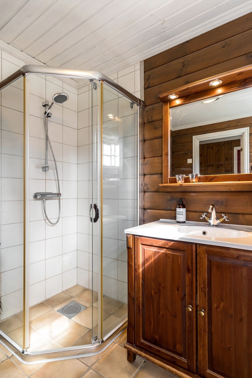 Badet er utstyrt med dusj og servantskap med heldekkende servantplate. Galleribilde