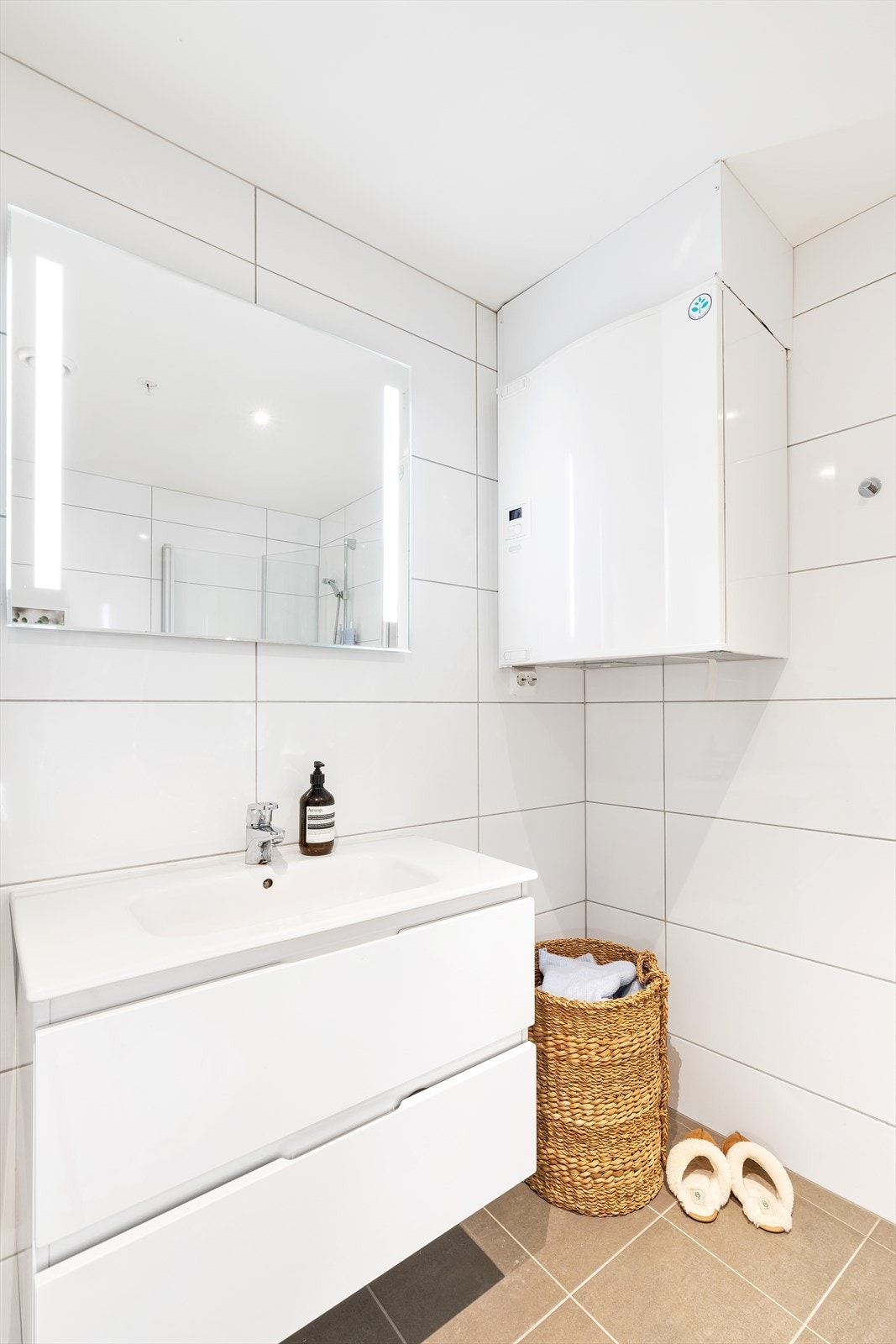 Flislagt bad med innredning som består av servant og skuffer Galleribilde