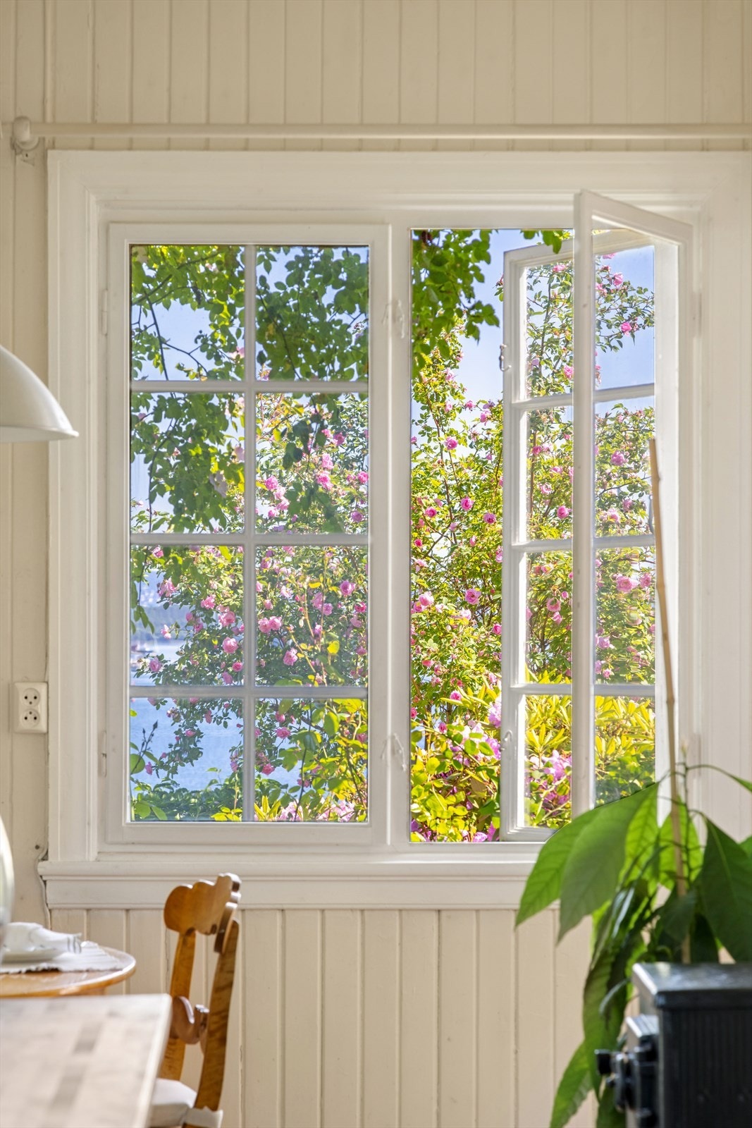 Utsikt fra kjøkkenvinduet over hagen er som en liten park - frodig og opparbeidet, med sjarmerende stier som slynger seg mellom rosebusker, hekk og paviljonger. Galleribilde