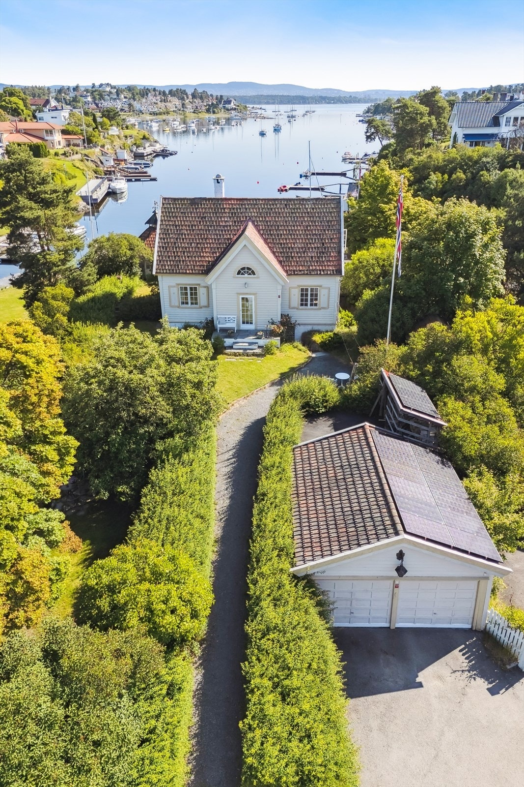 Det er gode parkeringsmuligheter i dobbel garasje og foran den. Det er lagt solpanel på taket til lading av el-bil. Galleribilde