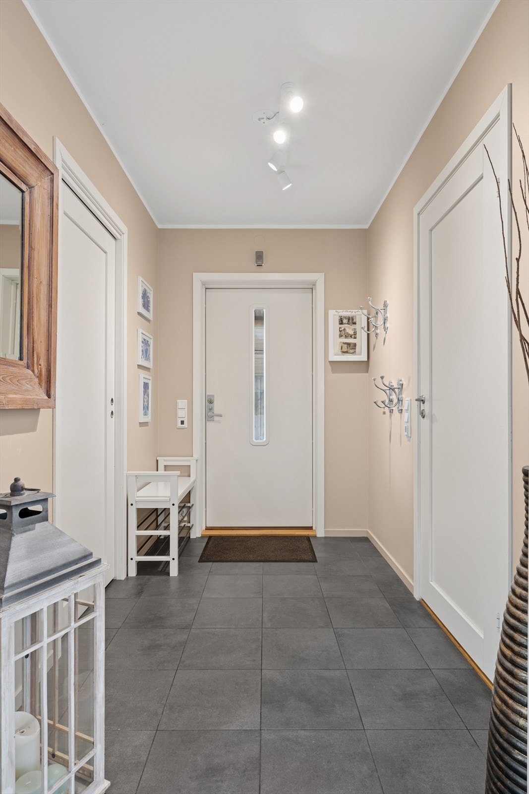 Stilren entré med fliser og gulvvarme. Til høyre i bildet ser du døren til bad/wc/vaskerom. Til venstre er det praktisk skyvedør til boden som blir et selvskrevet garderoberom. Galleribilde