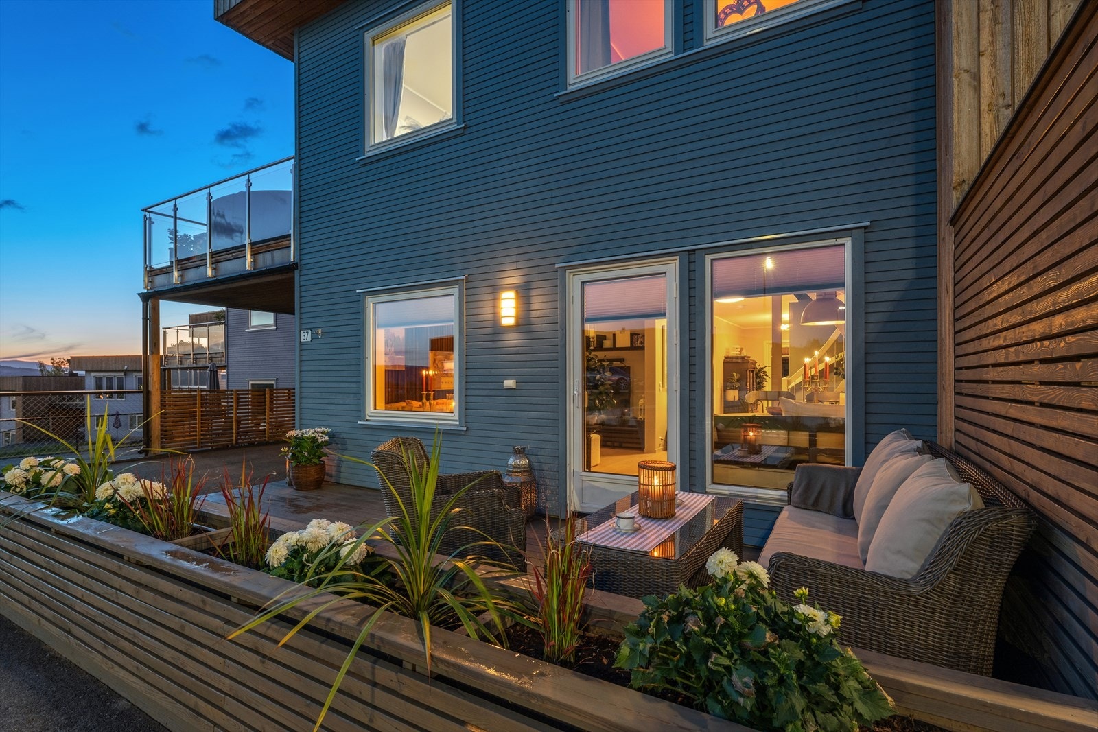Ut fra stuen er det terrasse med plassbygde og stilrene blomsterkasser. Sitt skjermet bak lekker beplantning. Galleribilde