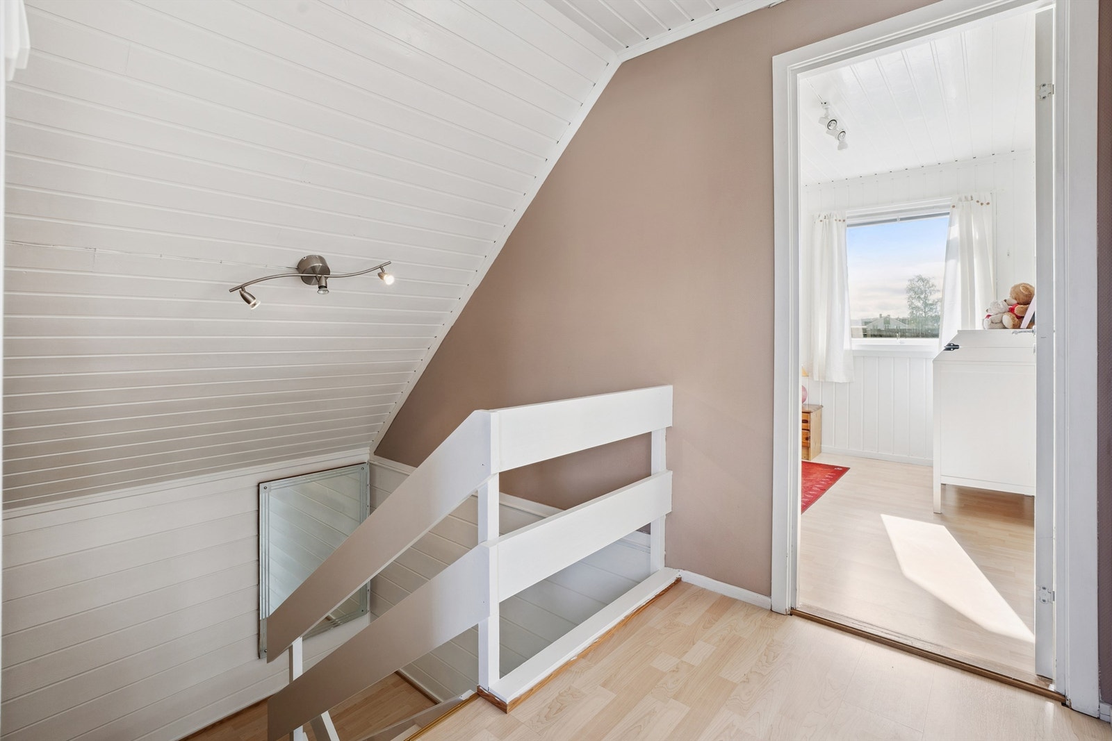 Den malte tretrappen leder opp til en gang som fordeler tilgang til soverommene. Galleribilde