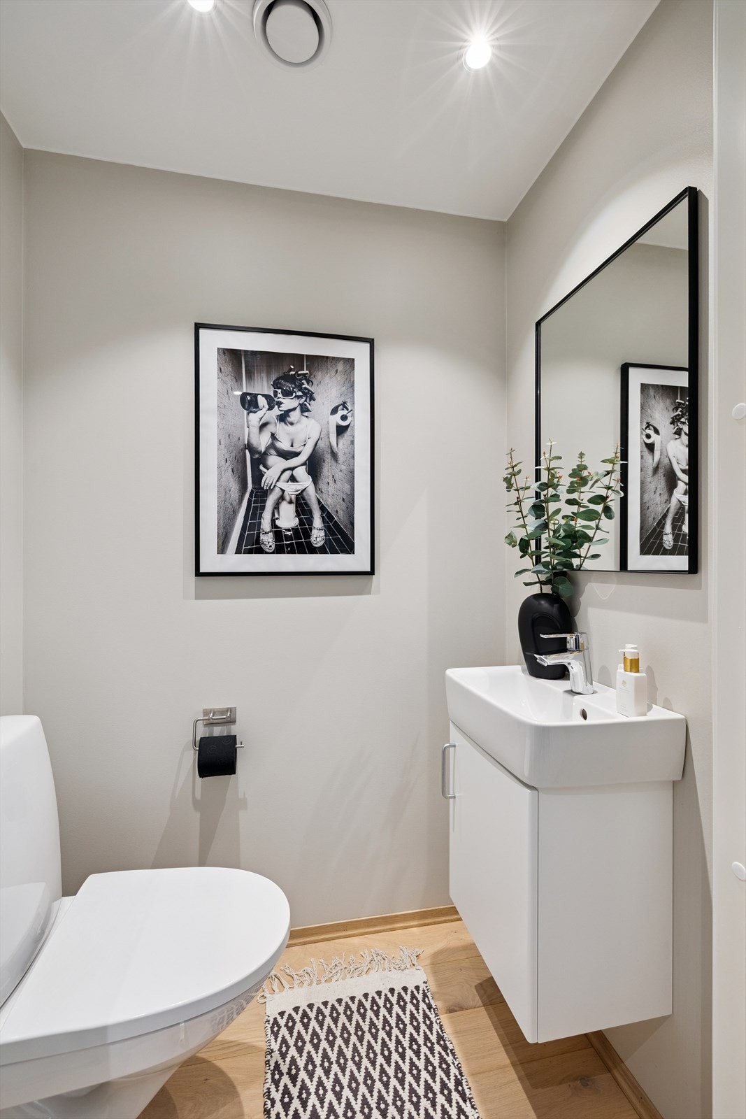 Praktisk plassert ved inngangen ligger et separat toalettrom med servant og vegghengt toalett. Galleribilde