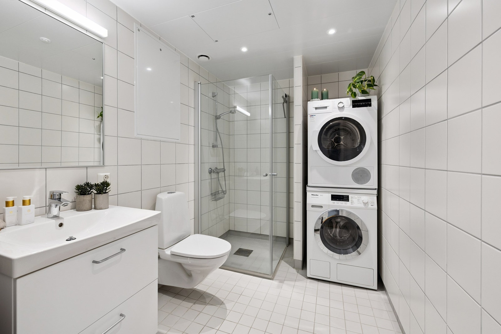 Badet er helfliset, har varme i gulvet, dusjhjørne og opplegg for vaskemaskin. Galleribilde