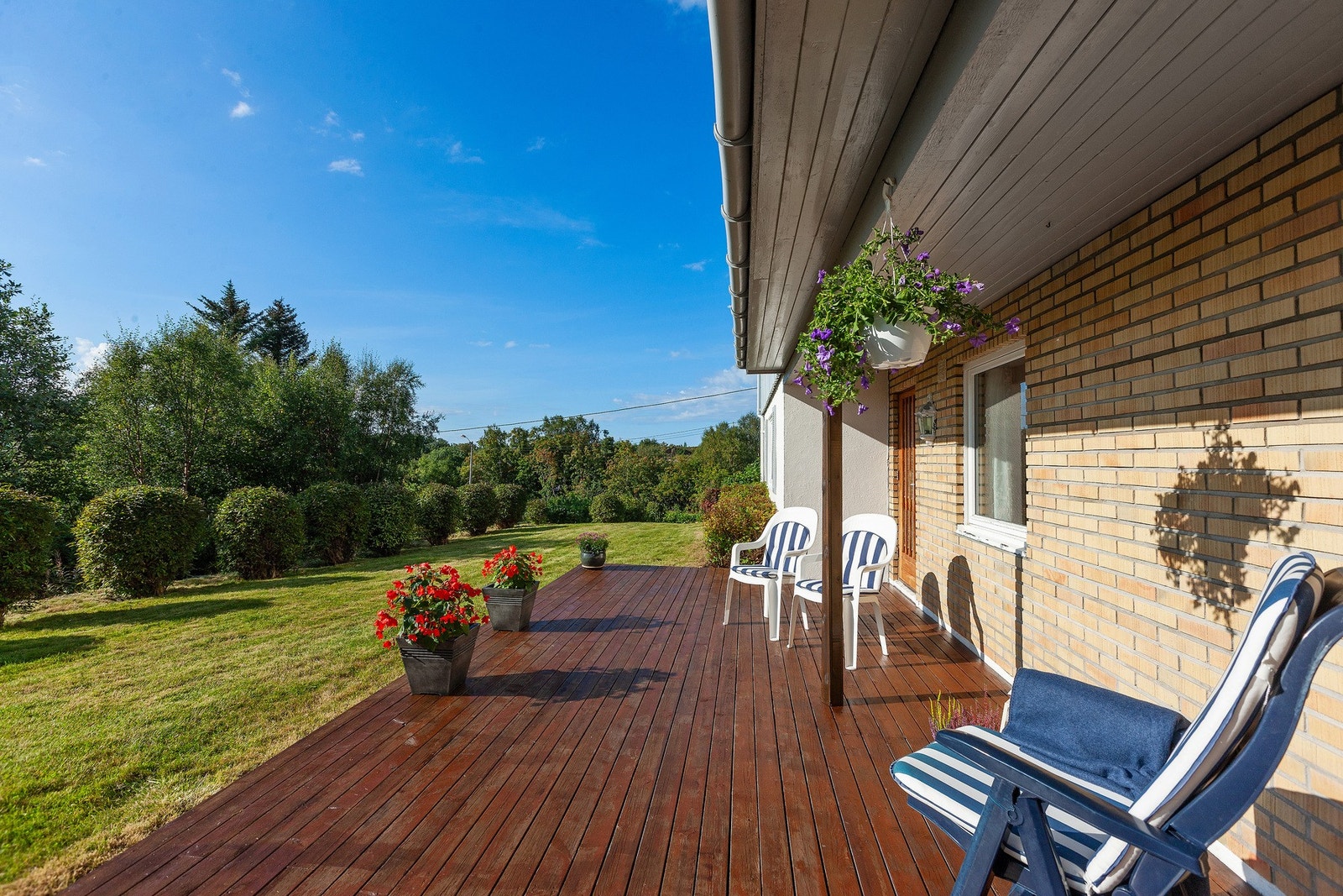 Eiendommen har fine uteområder - her er terrasse med tilgang fra gang i underetasje Galleribilde