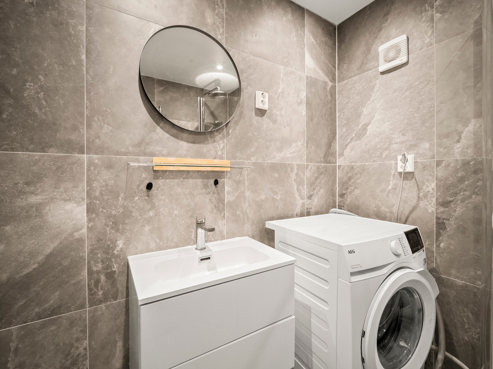 Effektiv løsning med servant, dusjkabinett og opplegg til vaskemaskin. Galleribilde