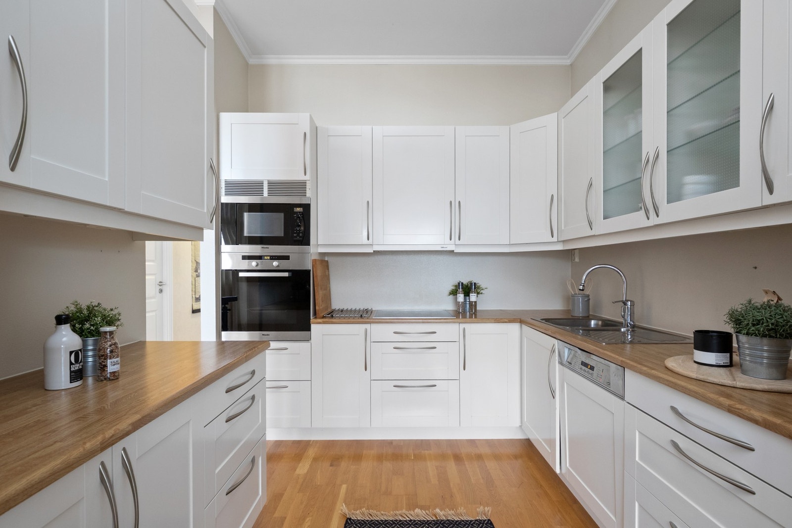 Hvite profilerte fronter kombinert med vitrineskap gir et tidløst preg. Galleribilde