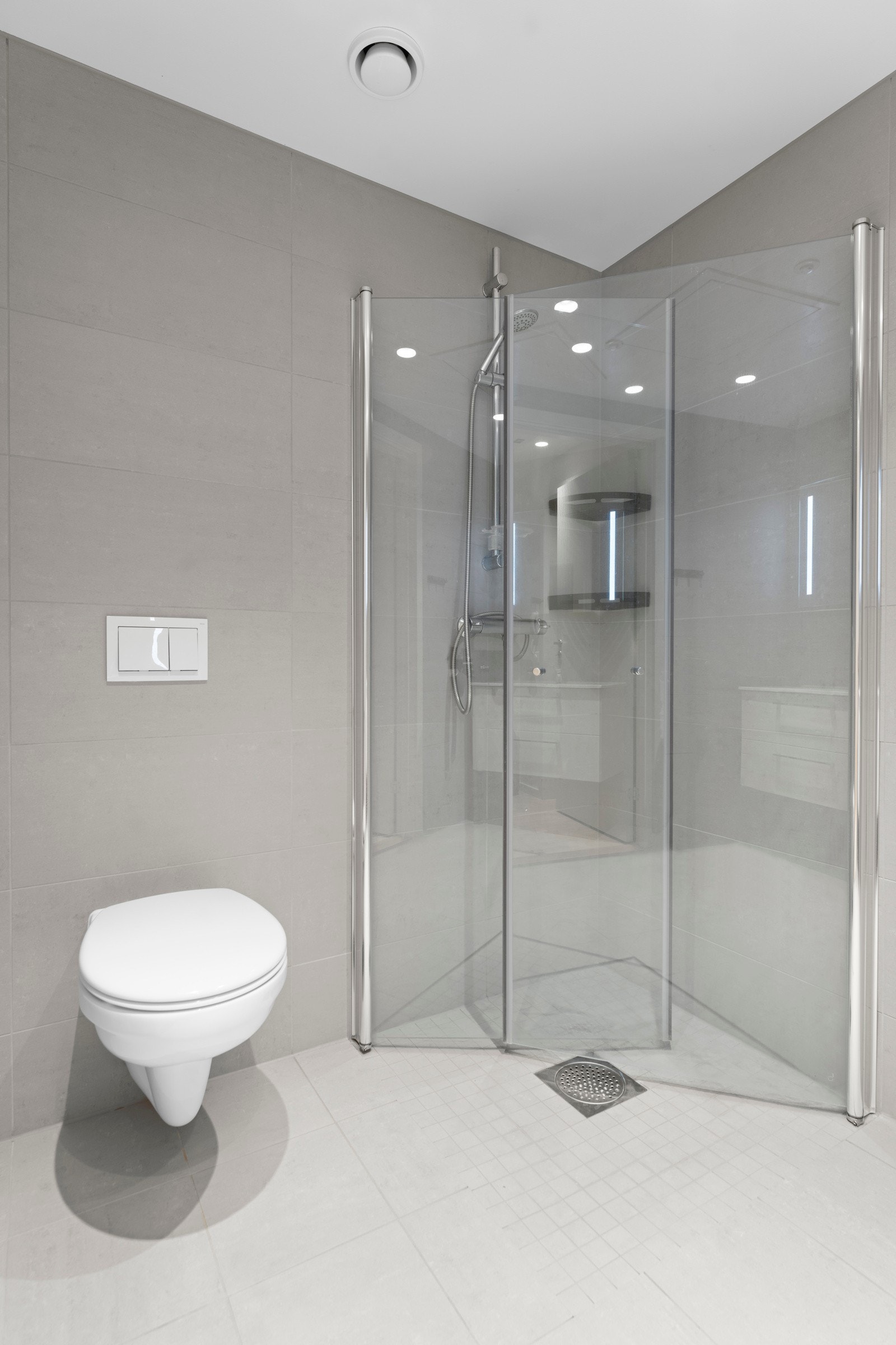 Badet har innredning med nedfelt servant, veggmontert toalett, dusjvegger/hjørne og opplegg for vaskemaskin. Galleribilde