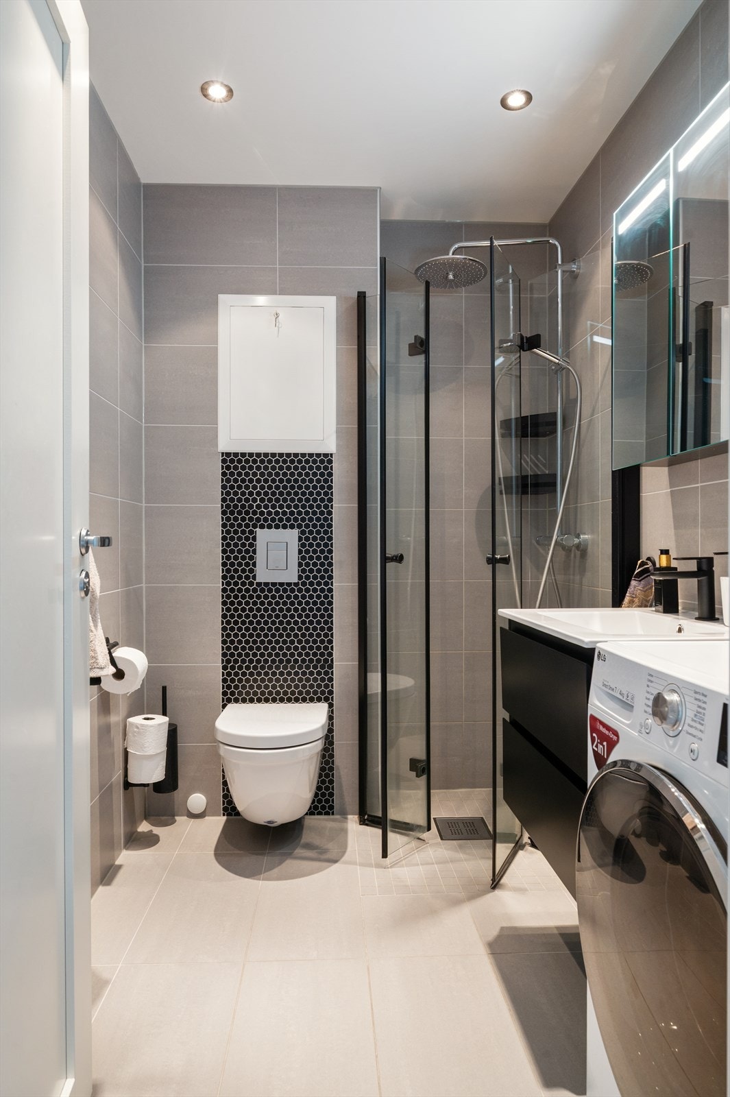 Badet har blant annet pene tidløse fliser, dusjhjørne med vannfallsdusj og opplegg for vaskemaskin Galleribilde