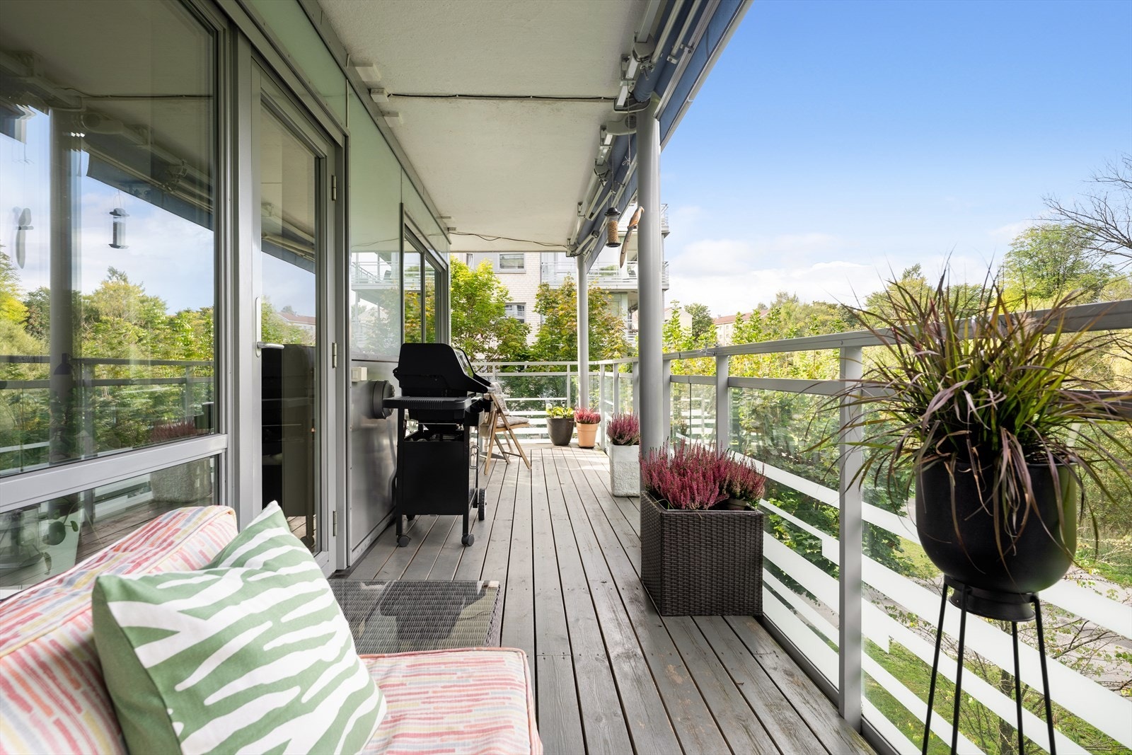 Balkongen har godt med plass til sittegruppe, beplantning, grill og folk Galleribilde