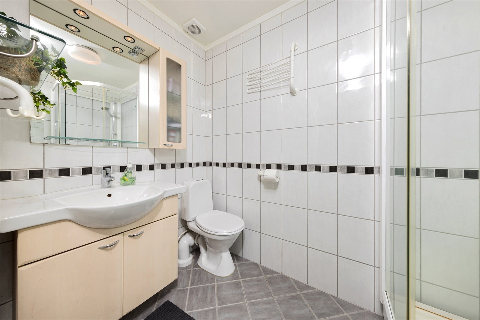 Badet er flislagt og ble oppgradert i 2006. Her er det elektriske varmekabler i gulvet som gir behagelig varme, flislagte vegger og malt himling. Badet er utstyrt med innredning med nedfelt servant, toalett og dusjkabinett. Galleribilde